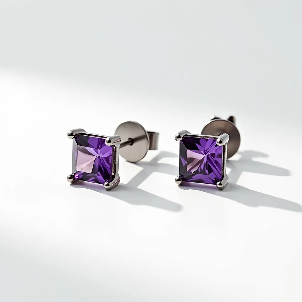 These titanium earrings feature a modern and sleek design with a pair of square-cut purple gemstones, elegantly set in a four-prong setting. The stones, likely amethyst or a synthetic equivalent, are showcased prominently and provide a vibrant contrast to the metallic sheen of the titanium. The earrings are attached with a push-back clasp, ensuring security and ease of wear. The use of titanium provides both durability and hypoallergenic properties, making these earrings suitable for sensitive skin while offering a contemporary aesthetic.