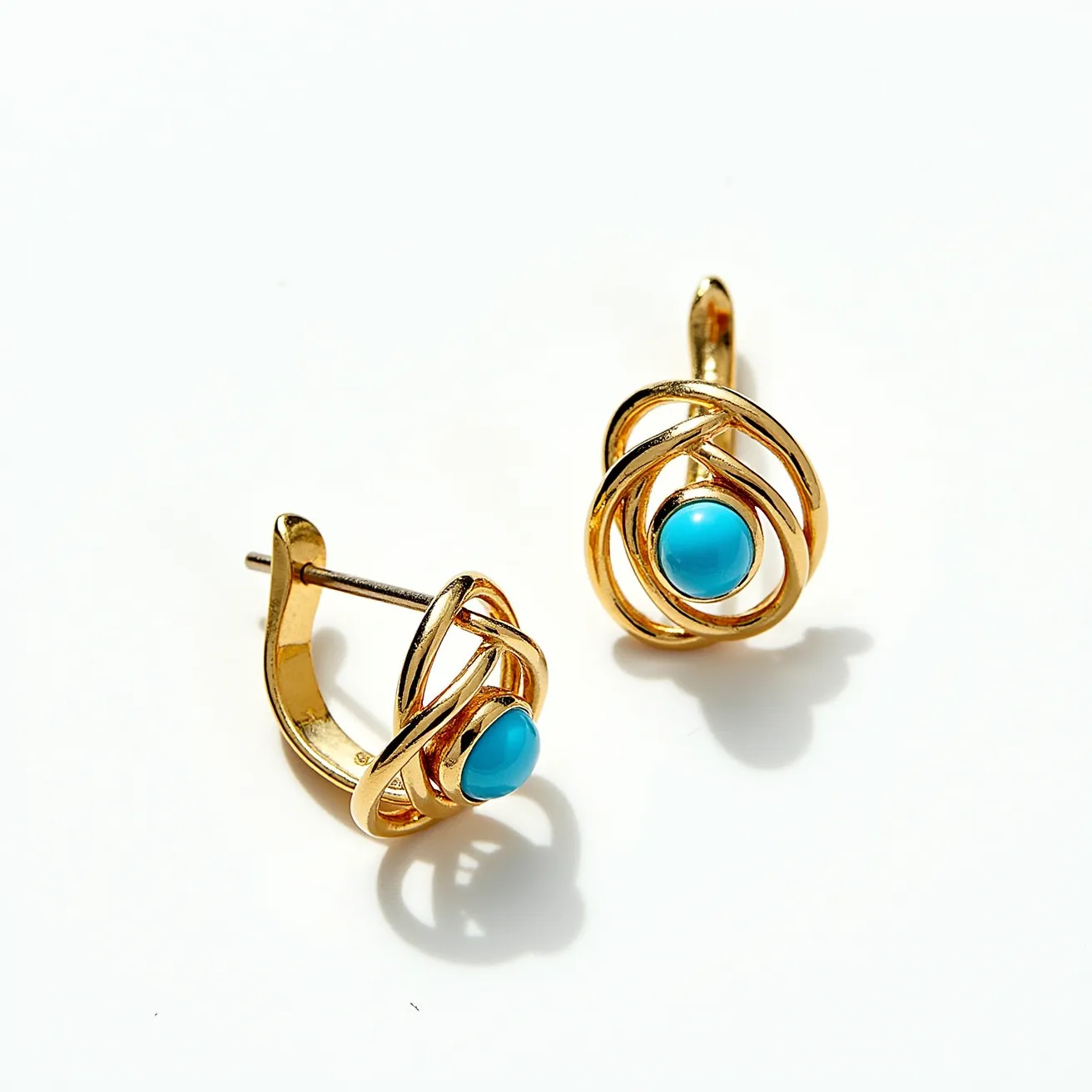 These turquoise stud earrings feature a striking central turquoise stone, which is smooth and likely round in form. The stone is elegantly set within a gold-colored metal frame characterized by a swirling, openwork design that adds an element of sophistication and movement. These earrings are secured with a conventional post and butterfly clasp, ensuring a comfortable and snug fit when worn. The combination of the vibrant turquoise and the warm metallic tone creates a timeless and elegant contrast, making these earrings a versatile accessory for various occasions.