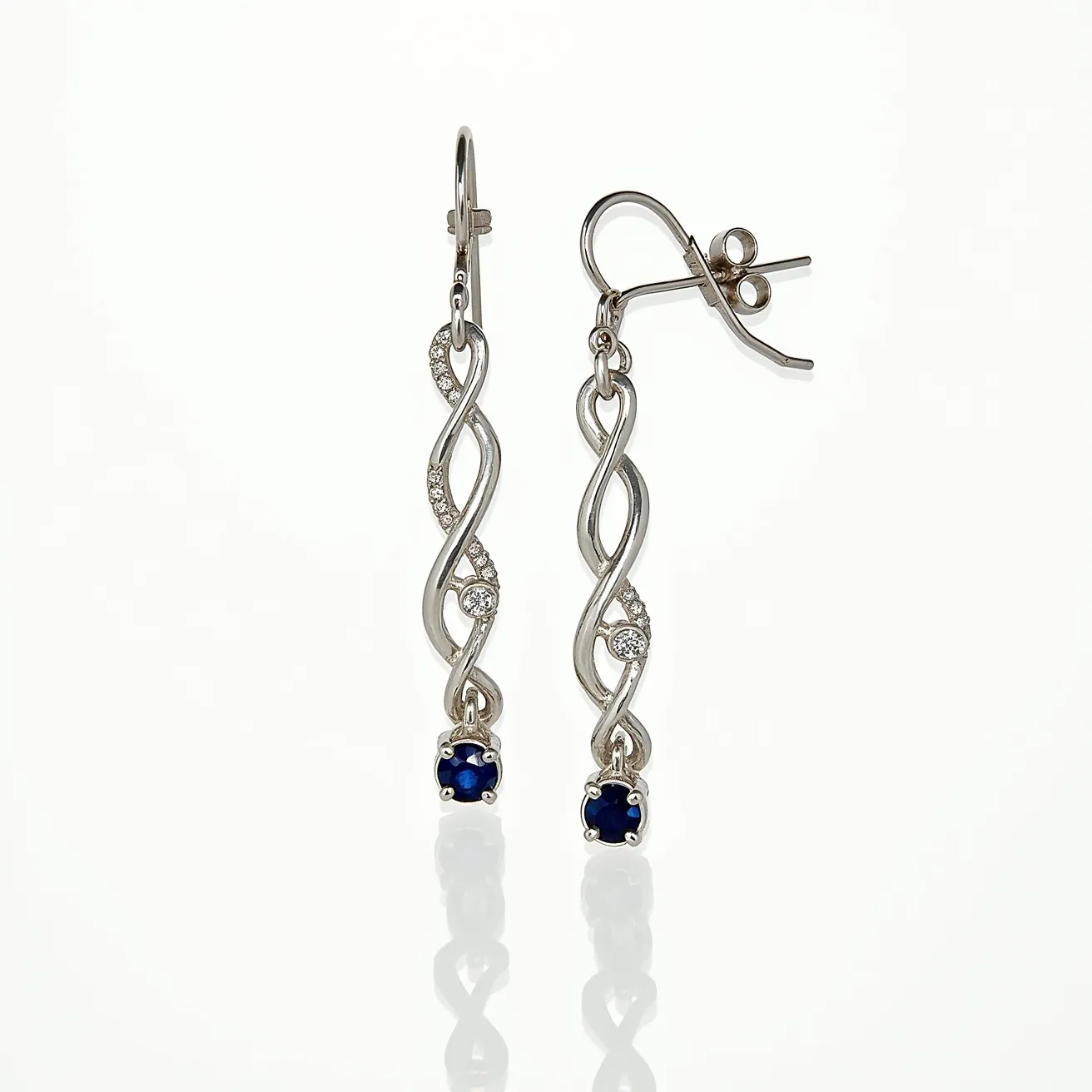 These twist earrings feature an elegant, intertwining design crafted from a metallic material, likely silver or white gold, which provides a sleek and polished look. Embedded along the twisted strands are several small, round-cut gems, presumably diamonds, set in a way that enhances their sparkle. At the bottom of each earring, a deep blue gemstone, likely a sapphire, is set in a prong setting, adding a touch of color and sophistication. The earrings are equipped with a lever-back attachment, ensuring a secure and comfortable fit for the wearer.