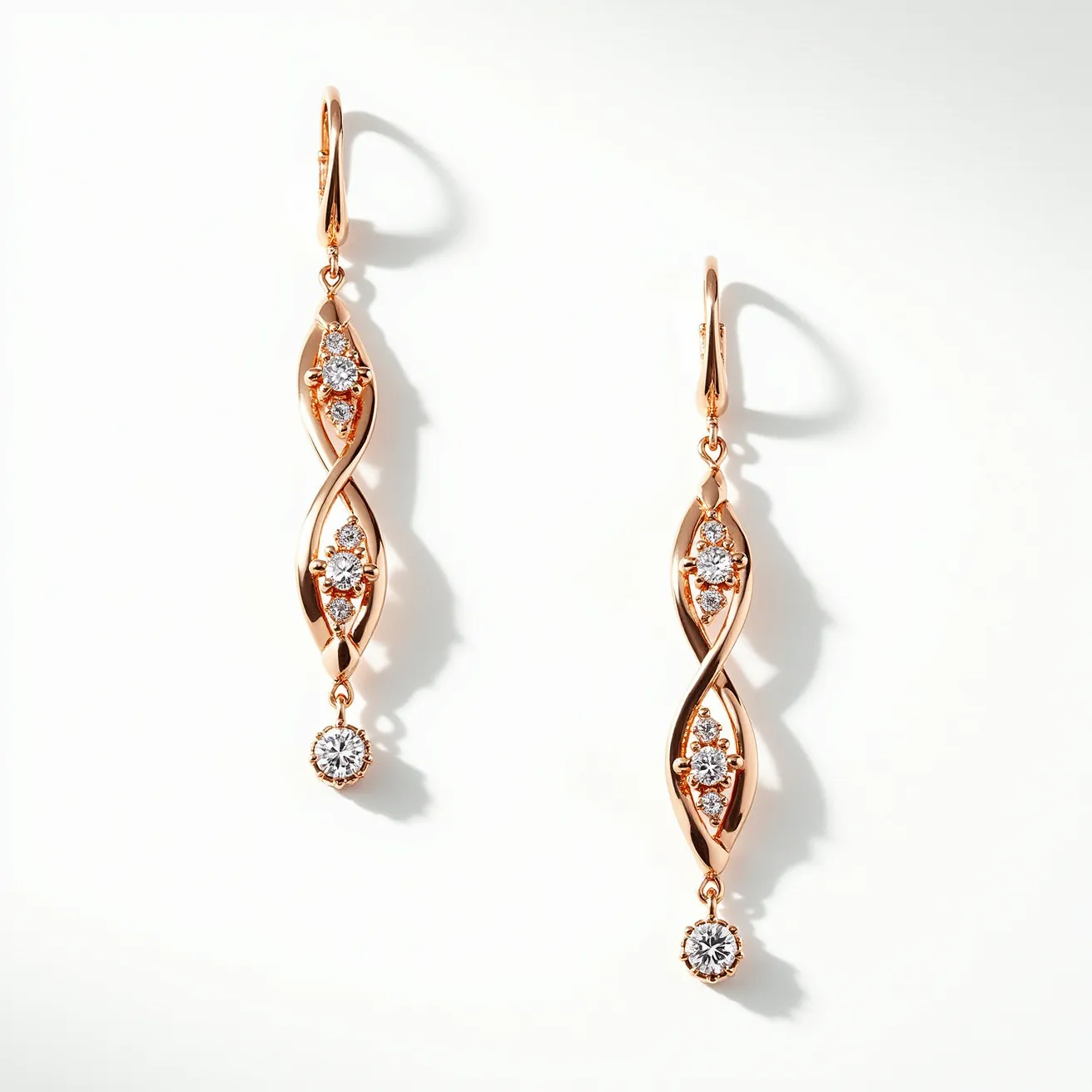 These twist earrings feature a sleek design crafted from a warm-toned metallic material, likely rose gold, which complements the sparkle of multiple gemstones. The earrings display several round-cut diamonds, expertly set within the twisting form to maximize their brilliance. Each earring culminates in a single dangling diamond, securely held in a bezel setting. The earrings are attached with lever-back clasps, ensuring both security and comfort for the wearer. The elegant interplay of metal and gemstones offers a sophisticated and timeless appeal.