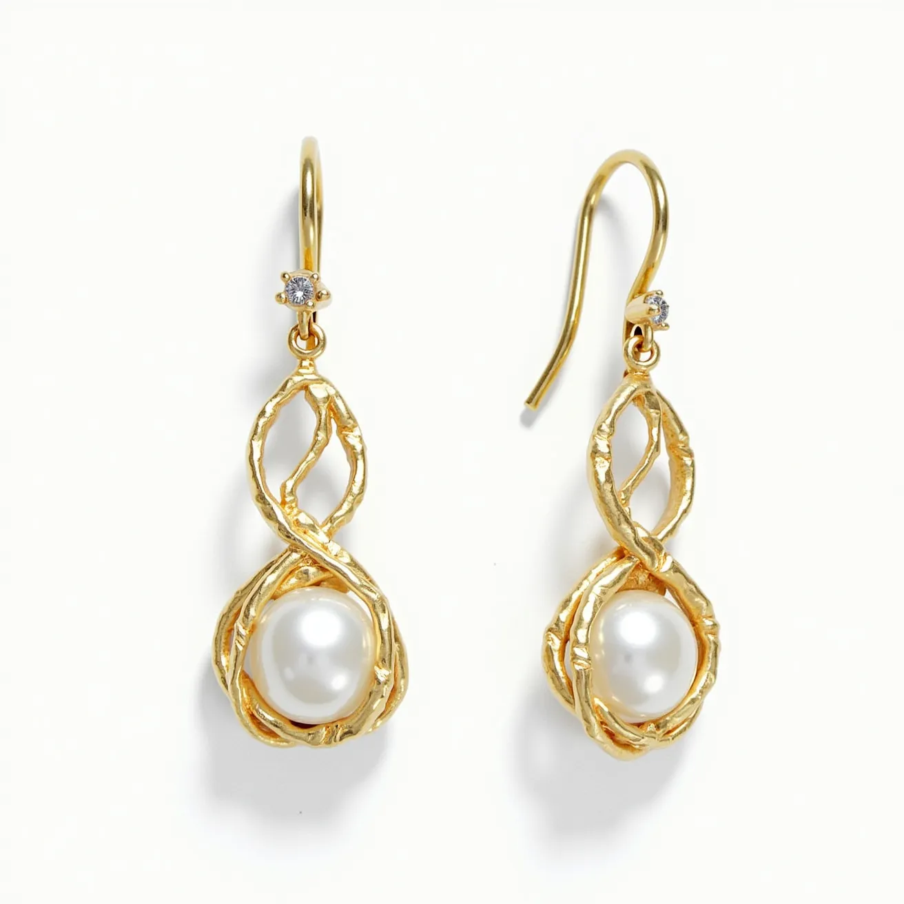 These twist earrings showcase an elegant design with gold-toned metal forming a twisted, open loop structure that gracefully cradles a lustrous white pearl. Each earring is adorned with a small, round-cut clear gemstone, likely a diamond or cubic zirconia, set in a simple, classic prong setting near the top of the twist. The earrings feature a hook clasp that allows for easy and secure attachment. The combination of the gold color with the white of the pearl and the sparkle of the gemstone creates a sophisticated and timeless aesthetic.