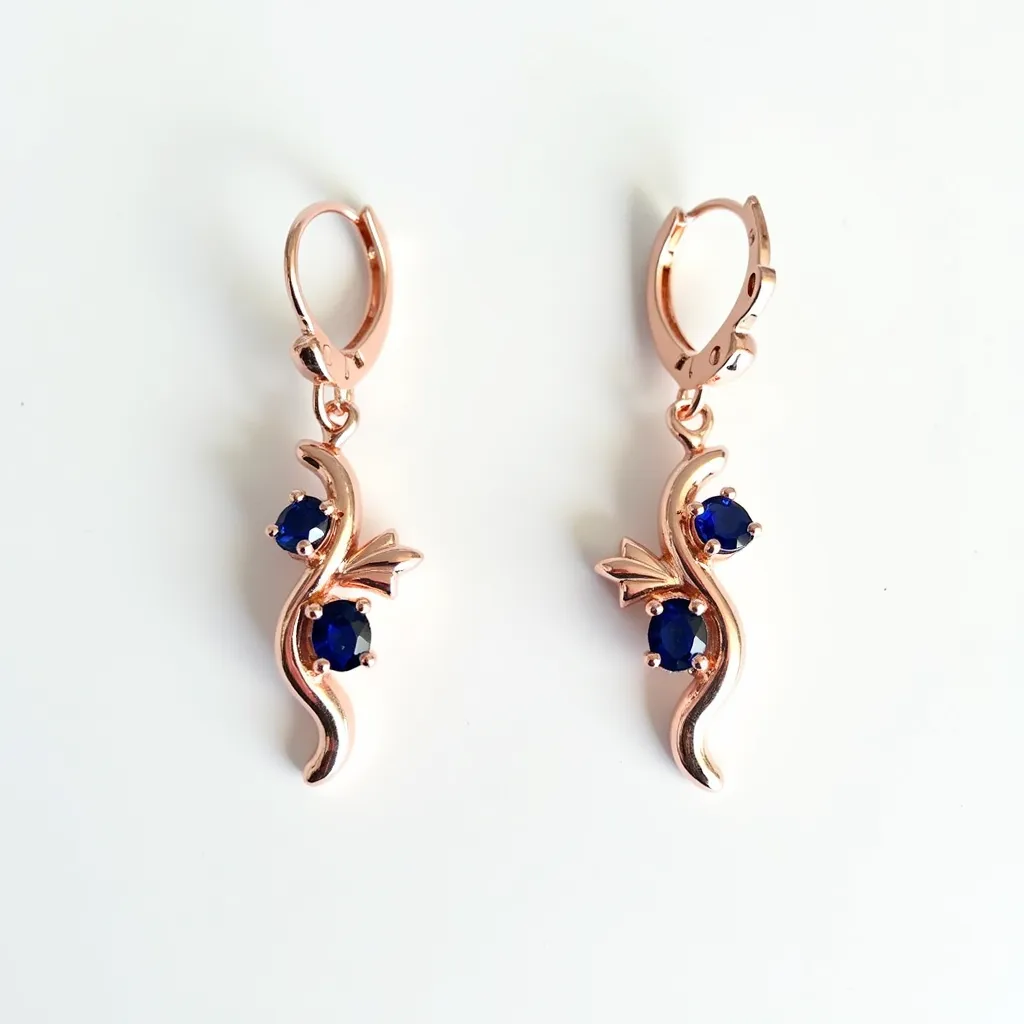 These twist earrings are elegantly crafted from a shiny metal, likely rose gold, and feature a flowing, vine-like design. Each earring is adorned with two round-cut blue gemstones securely held in a prong setting, adding a vivid contrast to the metallic hue. The design includes small, decorative leaf-like elements accentuating the natural motif. The earrings are equipped with a latch-back clasp, ensuring a secure and comfortable fit.