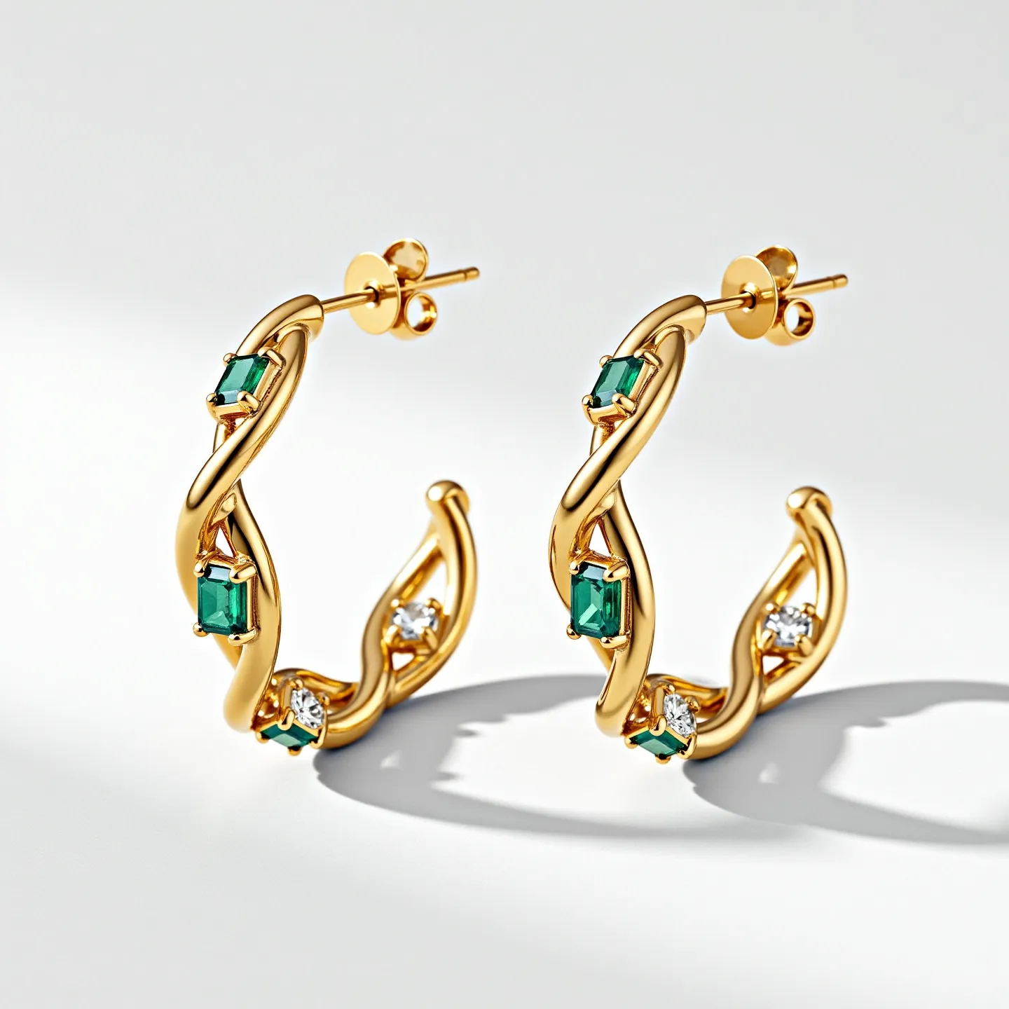 These twisted hoop earrings feature a gold-tone material with an elegant twisted design. They are accented with alternating green and clear gemstones. The green gems are rectangular in shape and are securely set in a prong setting, while the clear, round-cut stones are also held with prongs, providing a sparkling complement to the green stones. The earrings fasten with a standard post and butterfly clasp, ensuring a secure fit when worn.