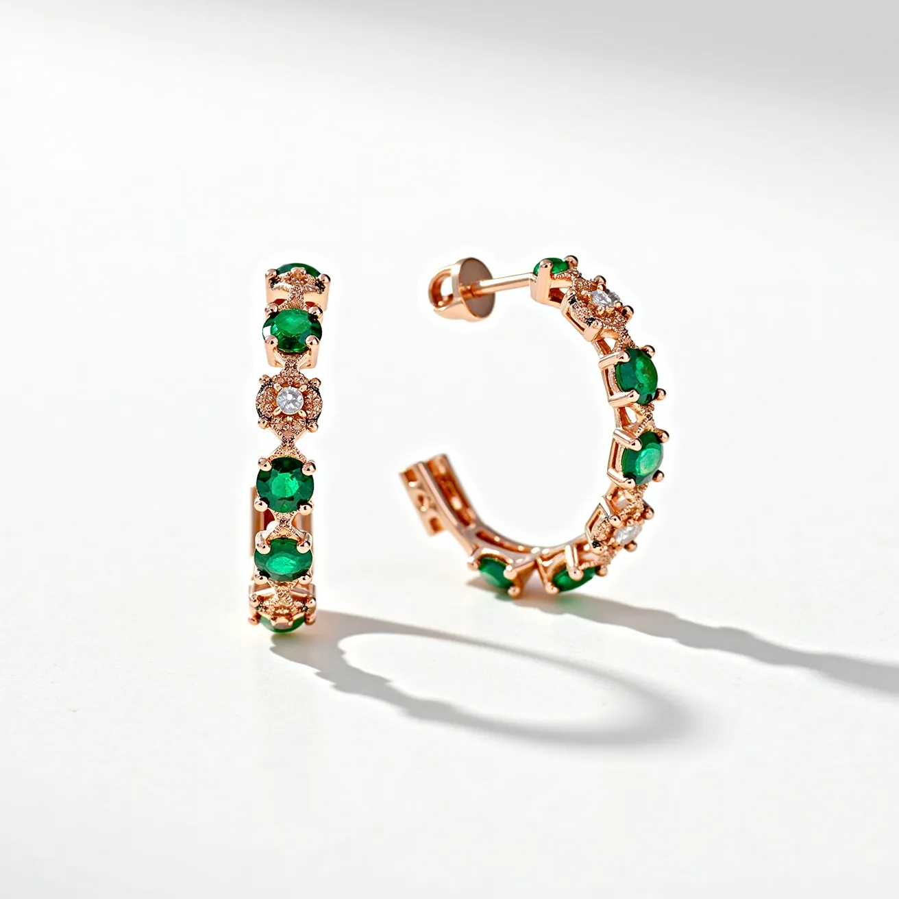 These twisted hoop earrings are crafted from a lustrous rose gold material, creating a warm and elegant base. They are adorned with vibrant green gemstones, likely emeralds, which are round in cut and provide a vivid contrast against the metal. Interspersed between the emeralds are smaller white stones, possibly diamonds, offering a sparkling accent that enhances the overall allure. The stones are set in a prong setting that securely holds each gem, allowing maximum light reflection. The earrings feature a post and butterfly back clasp, ensuring a secure and comfortable fit for the wearer.