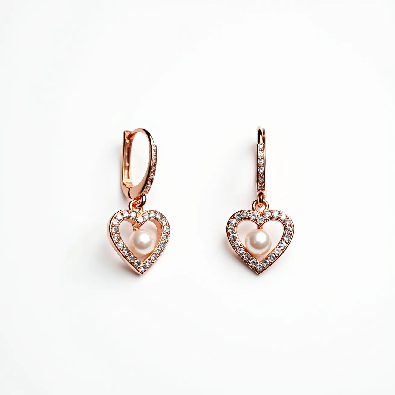 These valentines earrings are crafted from a lustrous rose gold metal, featuring a heart-shaped design that is elegantly adorned with small, round-cut clear stones set in a pavé style. At the center of each heart dangles a smooth, round pearl, which adds a touch of classic elegance to the piece. The earrings are attached with a polished lever-back clasp, ensuring a secure and comfortable fit while highlighting their romantic theme.