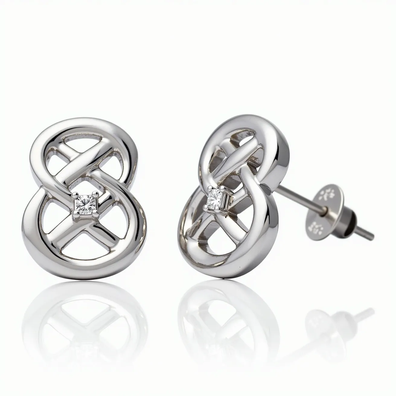 These white earrings feature a modern, intertwined design crafted from a polished, metal material that resembles white gold or platinum. At the center of each earring is a small, clear gemstone, likely a diamond, cut in a square shape and set securely within the loops using a prong setting. The earrings are equipped with a post and butterfly clutch back, ensuring a comfortable and secure fit when worn.