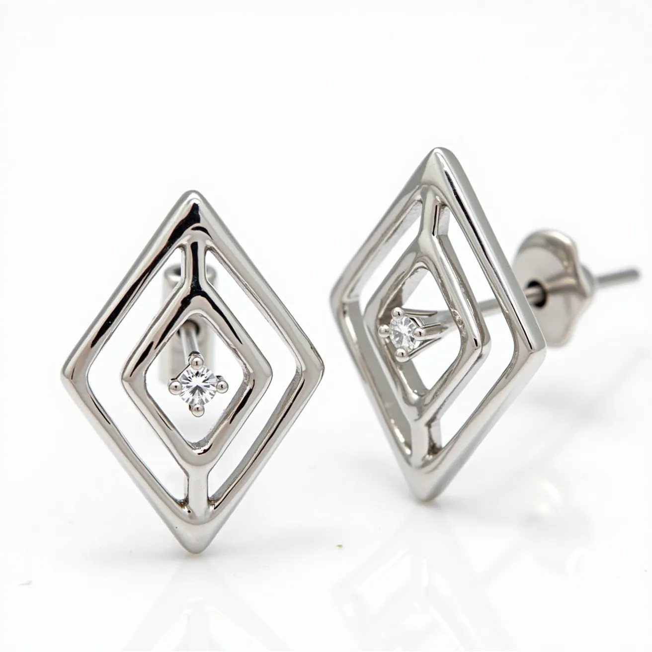 These white earrings exhibit a geometric diamond-shaped design crafted from a lustrous metal, likely white gold or silver. Each earring is adorned with a single round-cut gemstone, possibly a diamond or cubic zirconia, centrally positioned and set with a prong setting that highlights its brilliance. The earrings attach via a post and butterfly back clasp, ensuring a secure fit when worn. The overall design is modern and elegant, making these earrings suitable for both casual and formal occasions.