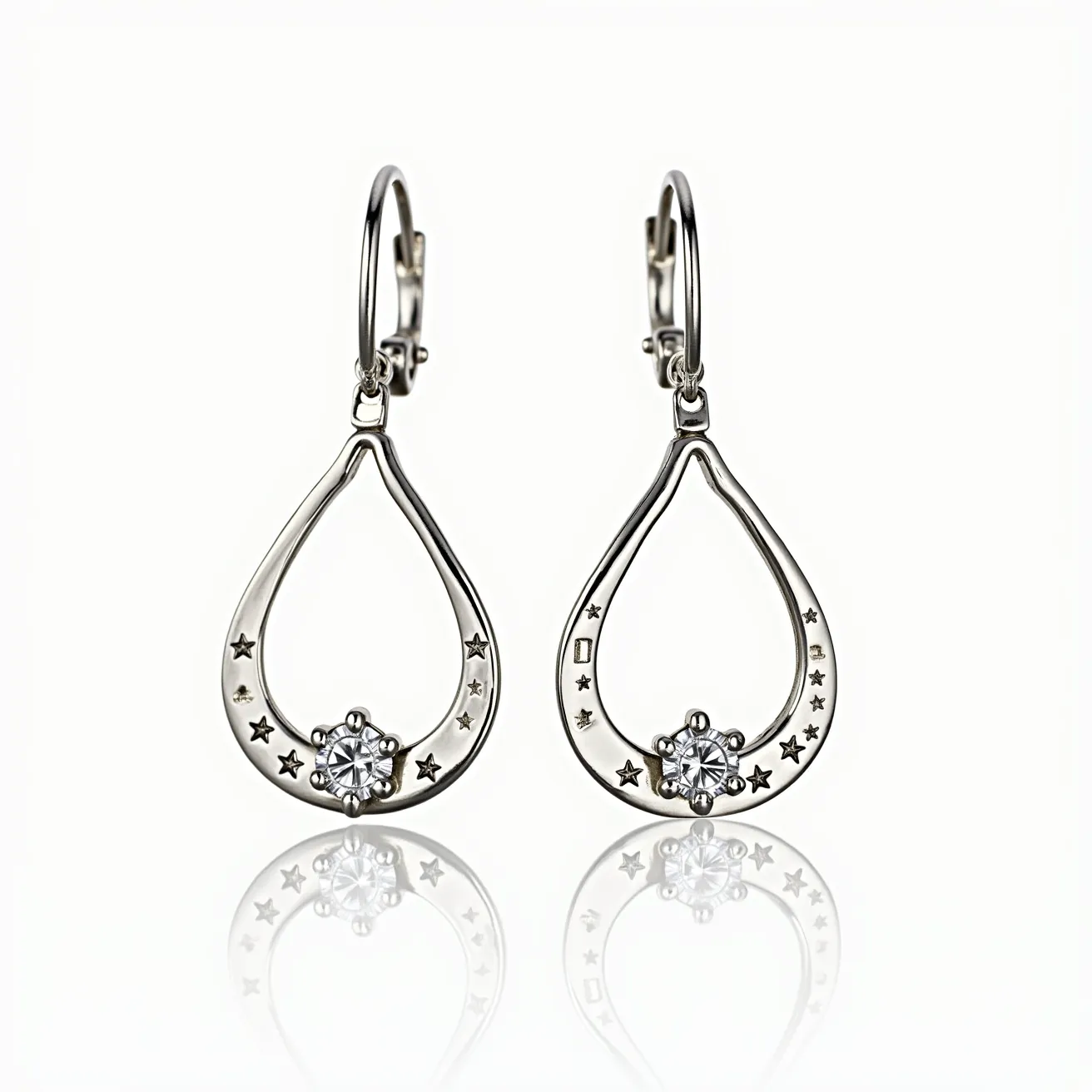 These white gold earrings feature an elegant teardrop design, embellished with small star-shaped engravings along the curve. At the center of each earring, there is a round-cut clear gemstone set in a classic four-prong setting, adding a touch of brilliance and sophistication. The earrings are secured with lever-back clasps, ensuring both comfort and security when worn. The sleek and polished finish highlights the luxurious nature of the white gold, making these earrings a perfect accessory for any elegant occasion.