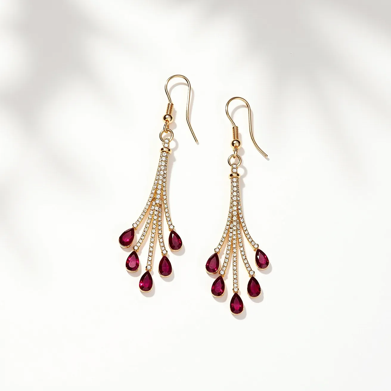 These wire earrings are crafted from a gold-toned metal, elegantly designed with multiple strands that fan out in a graceful arc. Each strand is adorned with a row of small, round-cut gems that appear to be clear stones, set in a delicate pavé setting to enhance their sparkle. At the end of each strand hangs a teardrop-shaped gem, likely ruby or a similar red stone, contributing a bold color contrast to the overall design. The earrings feature fishhook clasps for easy wear, complementing the flowing, chandelier-like appearance of the jewelry.