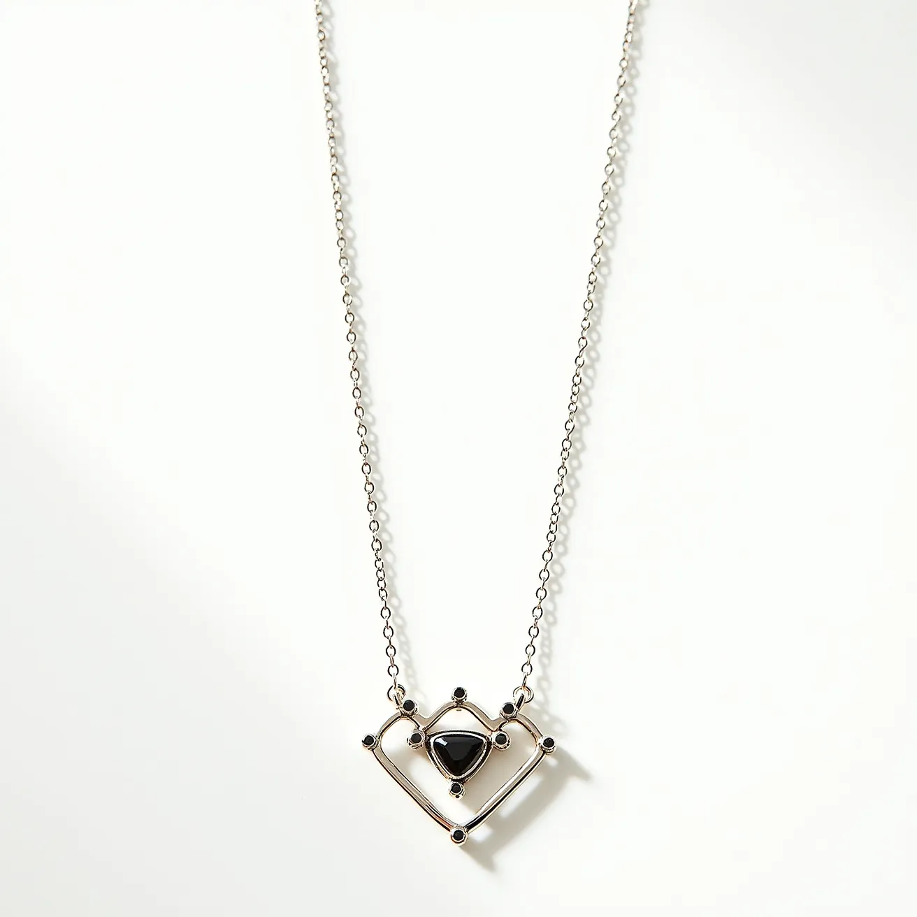 This alexandrite necklace features a unique pendant design showcasing a heart-shaped frame with a polished metal finish. At its center, a triangular stone is set within the frame, surrounded by small round accent stones strategically placed at various points around the geometric design. The necklace is suspended from a delicate chain, likely crafted from a similar metal to the pendant, ensuring cohesive aesthetics and durability. The chain is connected to the pendant through small, unobtrusive loops, allowing it to lay flat when worn. The necklace is secured with a standard clasp, providing ease of wear while maintaining the piece's elegance.