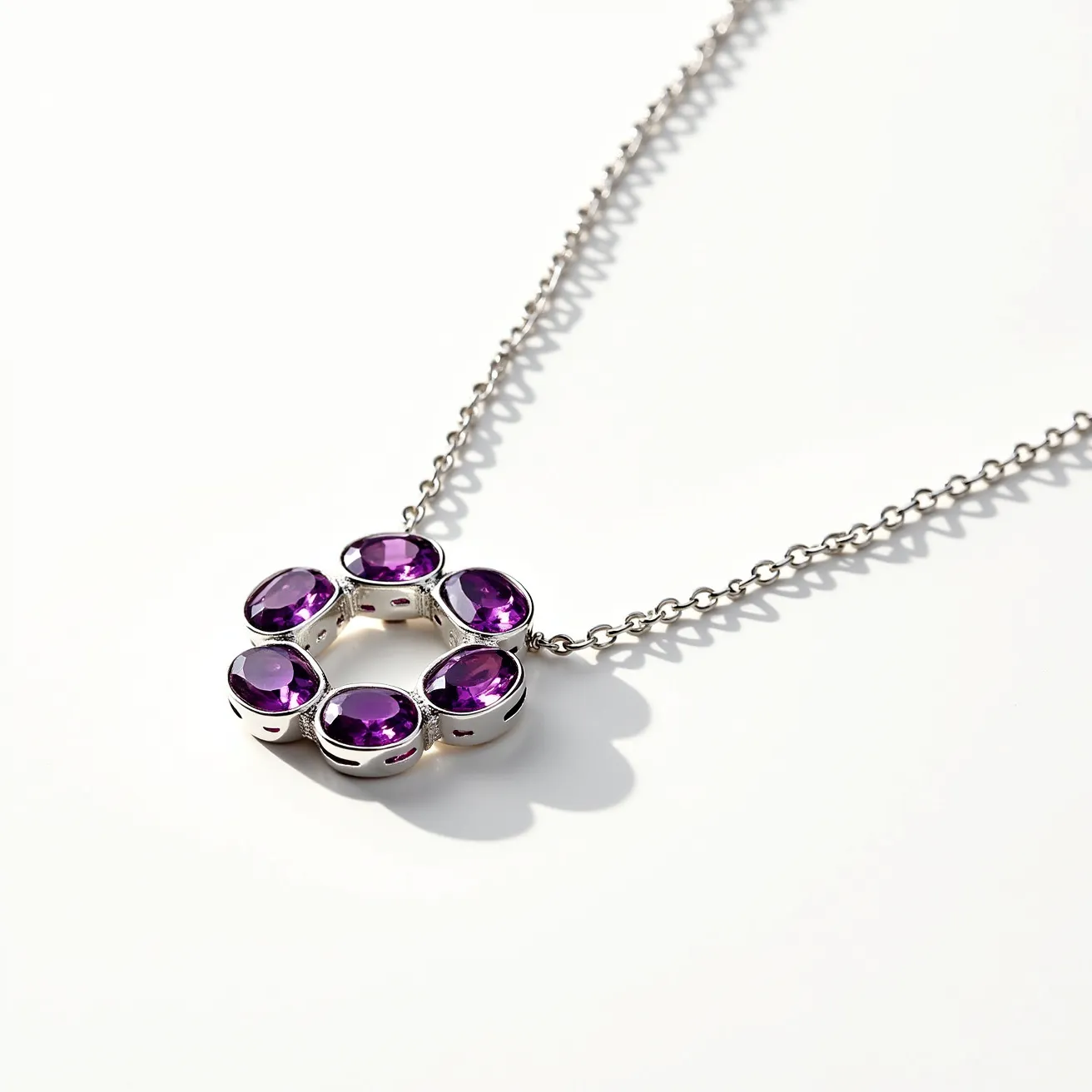 This alexandrite necklace features a striking arrangement of six oval-cut alexandrite stones, each set in a simple bezel setting that enhances their vibrant color and brilliance. The stones are connected in a circular design, offering a modern yet elegant focal point. The necklace is crafted from a high-polish metal, likely silver or white gold, which complements the gemstones’ hue. The chain is a classic cable style, adding a touch of timeless elegance, and is completed with a standard clasp for secure and easy attachment.