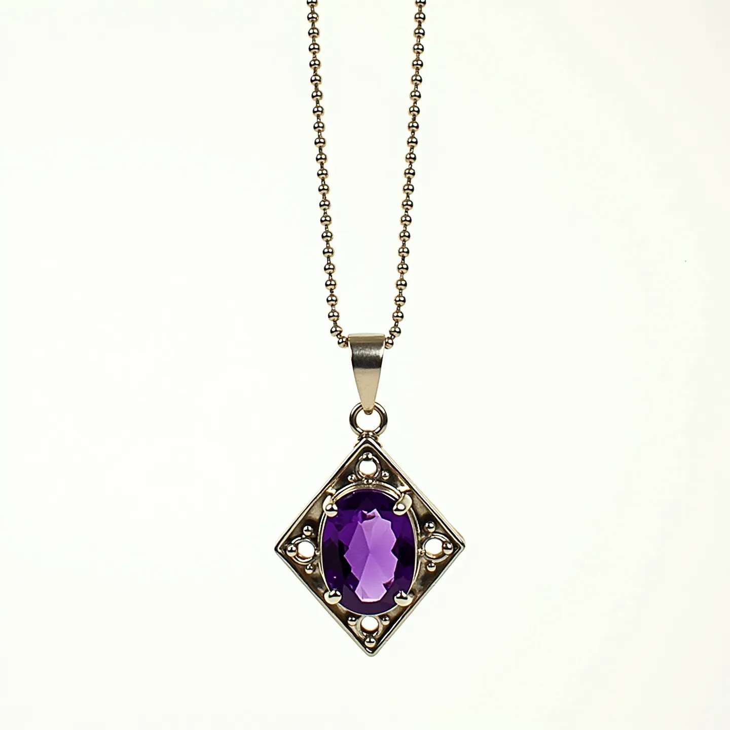 This amethyst necklace features a beautifully cut oval amethyst set in an ornate, geometric diamond-shaped metal setting. The amethyst exhibits a vibrant purple hue, enhanced by its faceted oval cut that captures the light elegantly. The metal framework surrounding the stone includes additional decorative elements that complement the central gem. The pendant is suspended from a delicate chain composed of small, interlinked beads, adding a subtle texture to the necklace. The connection between the pendant and the chain is facilitated by a simple, polished metal bail, ensuring both functionality and harmony in design.