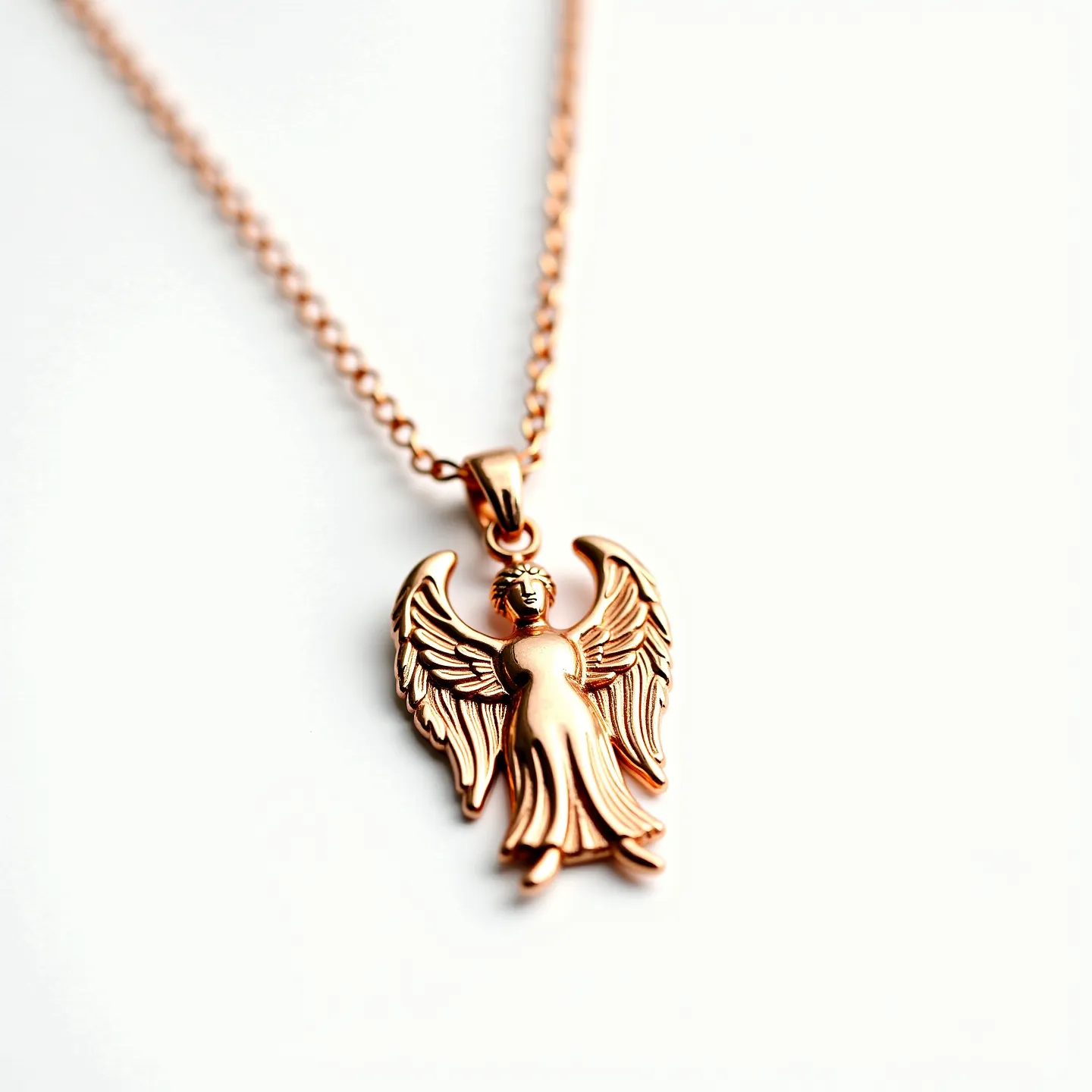 This angel necklace features a beautifully crafted angel pendant made from a rose gold-toned metal, highlighting delicate wings and a flowing robe. The design showcases intricate detailing in the angel's features, adding an elegant touch to the piece. The pendant is securely attached to a fine, matching chain that complements the pendant's finish. This necklace appears devoid of any additional gemstones, focusing on the simplicity and elegance of the angel motif. The chain is equipped with a standard clasp, ensuring it stays fastened comfortably and securely around the neck, making it both a stylish and versatile accessory.