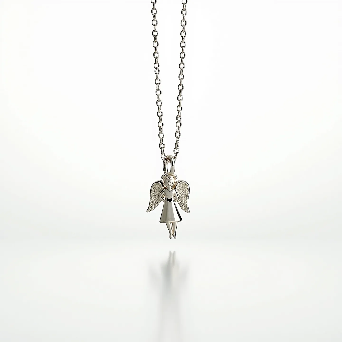 This angel necklace features a delicate pendant crafted from a metallic material, likely silver or white gold, designed in the shape of an angel. The angel's wings and robe have a smooth yet detailed finish, giving it a refined appearance. The chain is composed of round links, offering a classic and timeless look. There are no visible gemstones or embellishments on the piece, keeping it simple and elegant. The necklace is affixed with a standard loop attachment, allowing for smooth hanging from the chain.