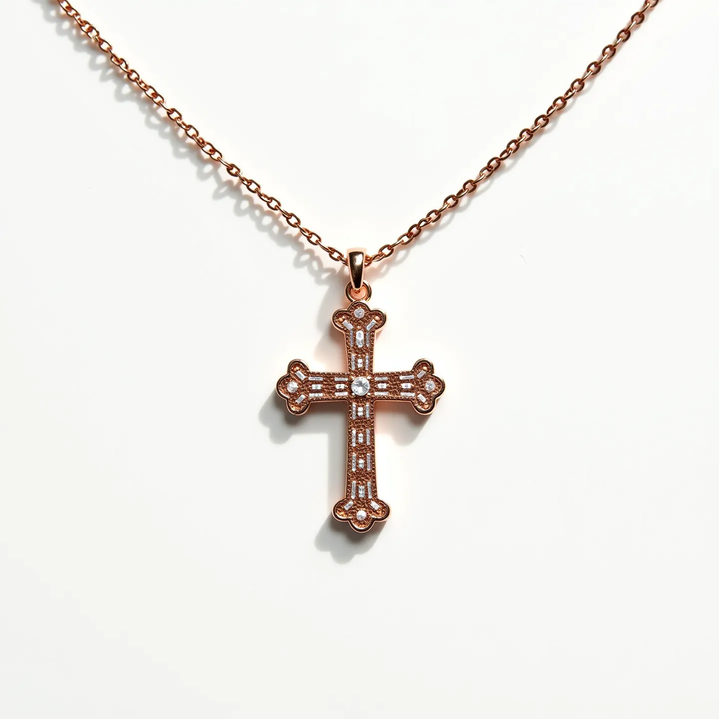 This baby cross necklace features a beautifully crafted pendant made from rose gold-toned metal, showcasing an intricate design with small, round-cut clear stones set into the cross. The stones are held securely in a prong setting, adding a touch of sparkle to the piece. The cross itself has a delicate, ornate pattern with rounded ends adorned with additional stones, enhancing its elegant appearance. The pendant hangs gracefully from a fine chain via a small, polished bail, offering a seamless and secure attachment. The necklace is completed with a subtle clasp, ensuring easy wear and removal while maintaining the design’s sophistication.