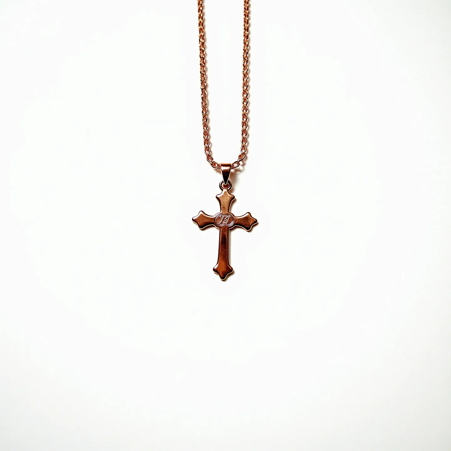 This baby cross necklace features a delicately crafted cross made of a rose gold-toned metal, giving it a warm and gentle appearance. The cross is embellished with a subtle, engraved pattern in the center that adds a touch of elegance to the design. It is attached to a fine chain that matches the cross in color and material, ensuring a cohesive look. The necklace utilizes a standard lobster clasp, providing a secure and reliable closure. Its simple yet refined design makes it suitable for everyday wear or as a meaningful gift for a special occasion.