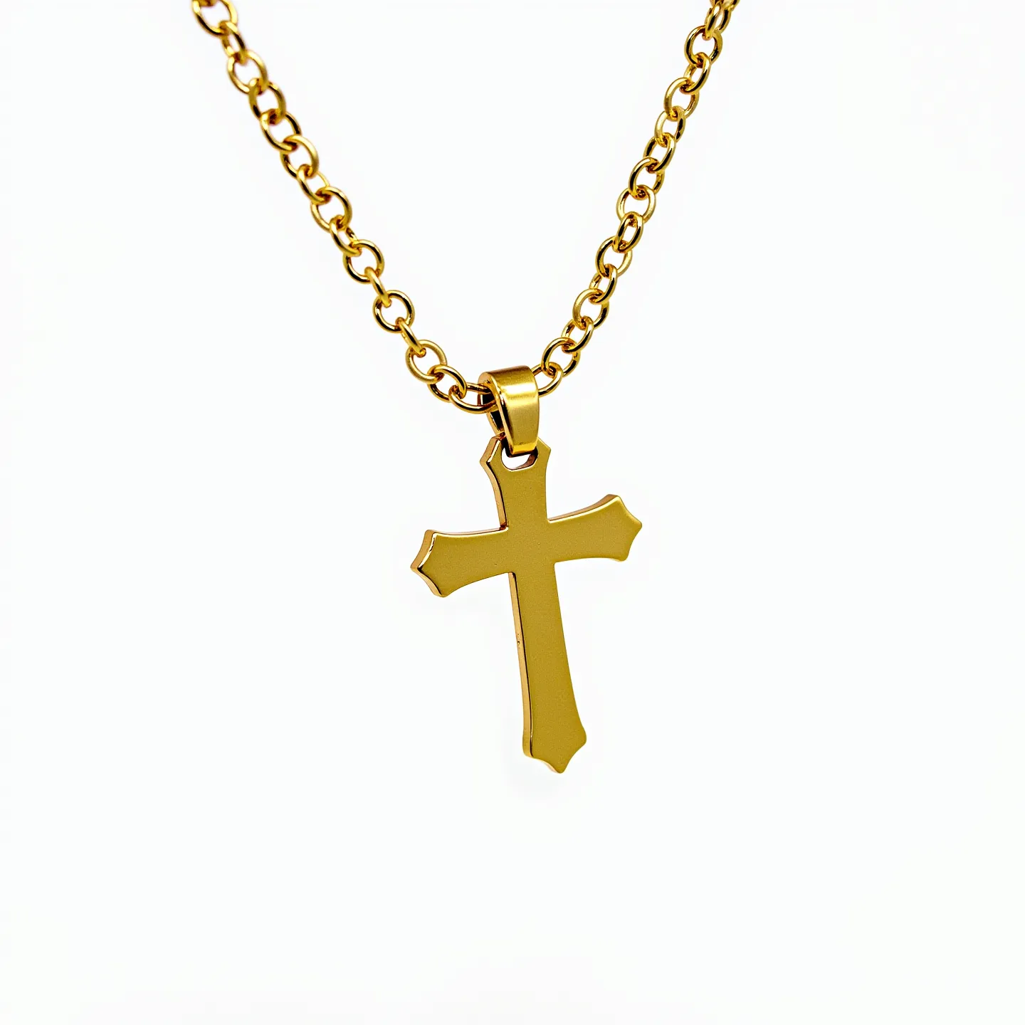 This baby cross necklace features a gold-toned design, showcasing a polished cross pendant with slightly flared ends. The necklace is composed of a series of round, interlocking links creating a stylish chain, indicative of gold plating or a similar metal finish. The pendant is attached to the chain through a simple, polished gold bail that allows for fluid movement along the chain. There are no visible gemstones or elaborate settings present, highlighting a minimalist and elegant aesthetic suitable for infants.