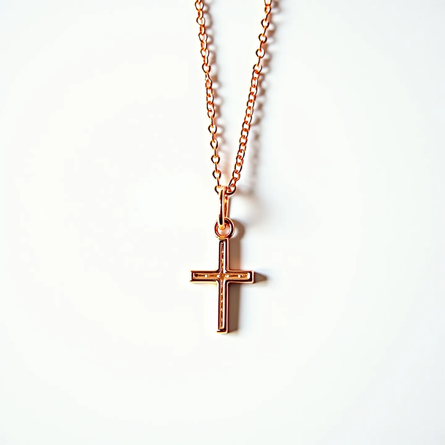 This baby cross necklace features a delicate cross pendant made of a lustrous metal, likely rose gold or a similar hue, adding a warm and elegant touch. The cross is simple and unadorned, emphasizing minimalistic charm. The pendant hangs from a finely linked chain, matching the color and style of the cross, providing a cohesive and sophisticated look. The necklace is equipped with a small, secure jump ring attachment, ensuring that the cross remains securely fastened while worn. This piece exudes an understated elegance suitable for a variety of occasions.