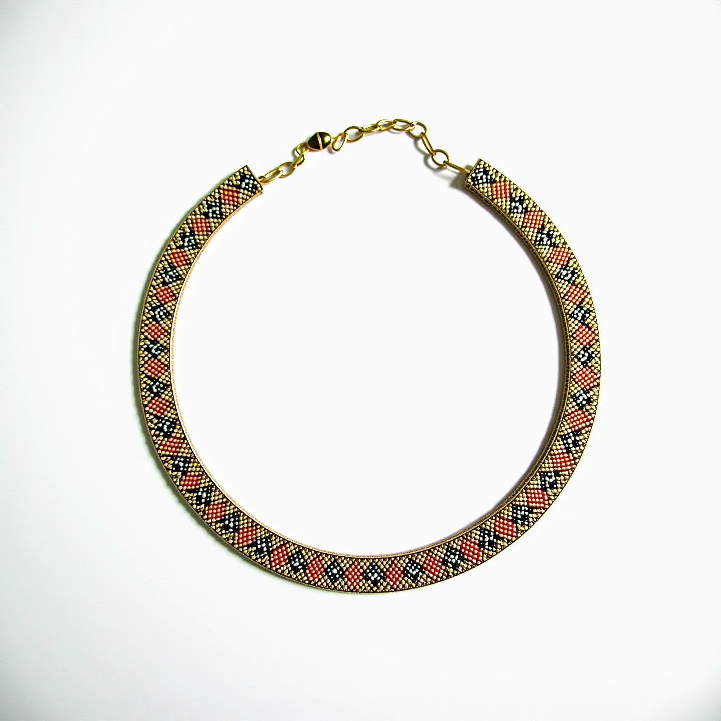 This beaded necklace features an intricate pattern that combines black, orange, and gold-toned beads, creating a harmonious and striking design. The beads are meticulously arranged to form geometric patterns, showcasing the skill and precision involved. The necklace includes gold-toned hardware, including an adjustable clasp and a small chain, which add both functionality and a touch of elegance. The clasp ensures a secure fit, and the extension chain allows for minor length adjustments, enhancing versatility. The overall craftsmanship reflects a blend of traditional artistry with contemporary aesthetics.