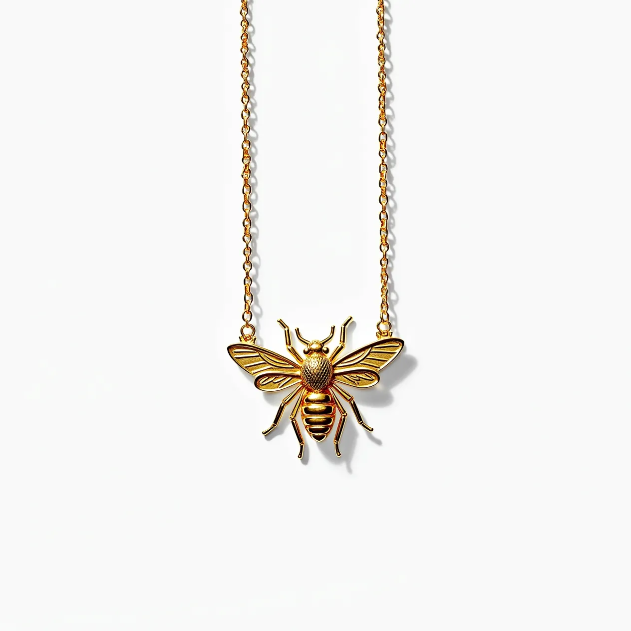 This bee necklace features a beautifully detailed pendant crafted from a metallic material with a striking golden hue. The bee design exhibits intricate details, with textured patterns on the wings and body, enhancing its lifelike appearance. The pendant is suspended from a delicate chain that matches the metallic finish of the bee, providing a cohesive and elegant look. The necklace's clasp is a standard closure that ensures secure and comfortable wear. This piece captures the essence of nature with a sophisticated touch, ideal for those who appreciate unique and artistic jewelry.