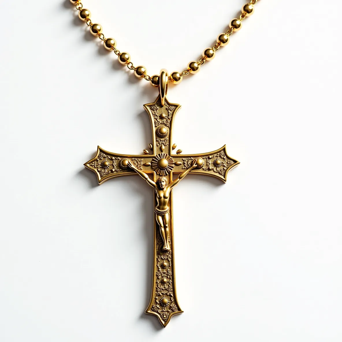 This big cross necklace features an intricate design crafted from what appears to be a gold-toned metal. The ornate patterning on the cross includes floral motifs adorned with small, spherical embellishments, suggesting a detailed metalwork technique. At the center of the cross is a depiction of Christ, adding a religious significance to the piece. The cross is suspended from a beaded chain with a secure, matching gold-toned bail, which connects seamlessly to the pendant. The craftsmanship and material choice give the necklace an elegant and traditional appearance, without any visible gemstones or complex settings.