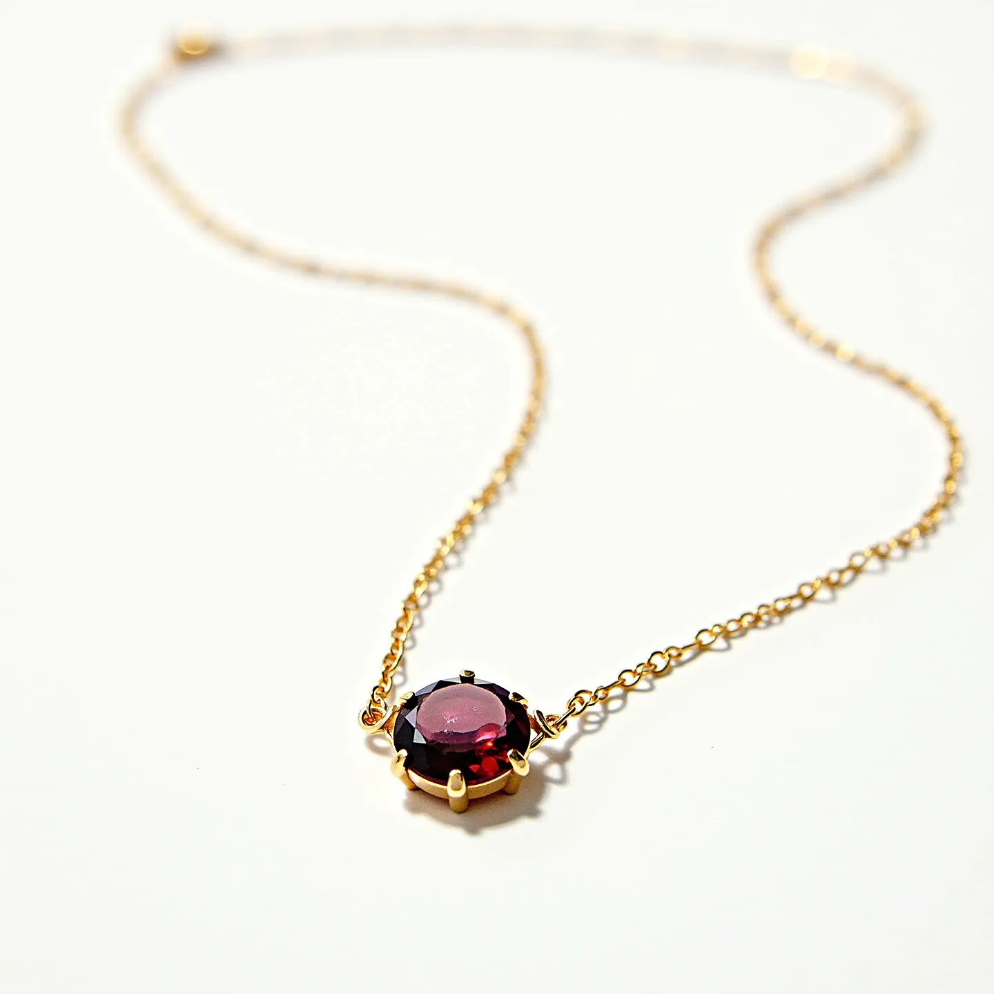 This birthstone necklace features a delicate gold chain that culminates in a round garnet gemstone. The garnet is set in a classic six-prong setting that secures the stone while showcasing its deep red hue, characteristic of January's birthstone. The chain is finely crafted, offering a seamless and elegant connection to the pendant. The necklace closes with a spring ring clasp, ensuring secure fastening and ease of wear. The overall design combines timeless elegance with a personal touch through the inclusion of the birthstone.