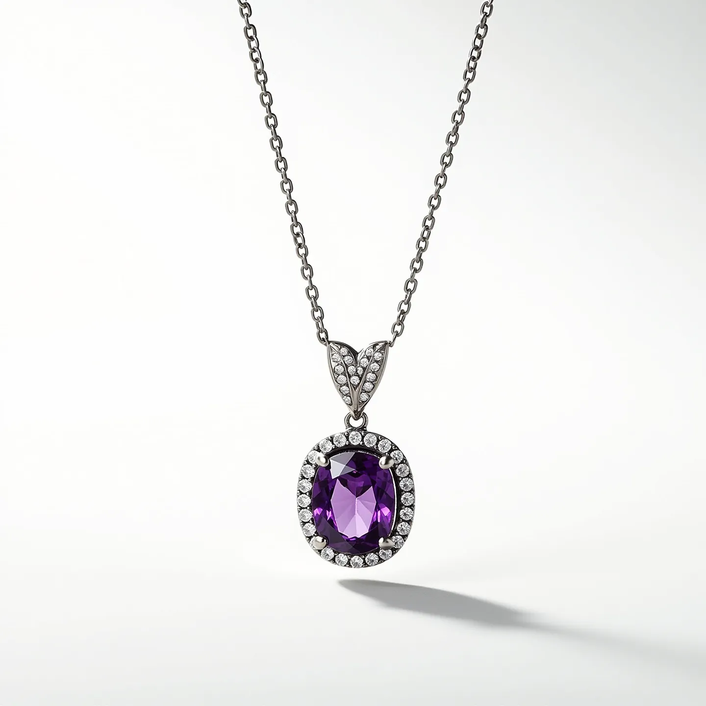 This birthstone necklace showcases an oval-cut amethyst at its center, surrounded by a halo of small round diamonds set in a polished metal, likely silver or white gold, enhancing its brilliant sparkle. The amethyst is securely held in place by prongs, ensuring durability and elegance. The pendant is suspended from a delicate, matching chain, which adds a subtle yet complementary style to the overall design. The chain appears to have a lobster clasp for secure fastening. The pendant's bail is also adorned with small diamonds, contributing to the overall luxurious appeal of this piece.