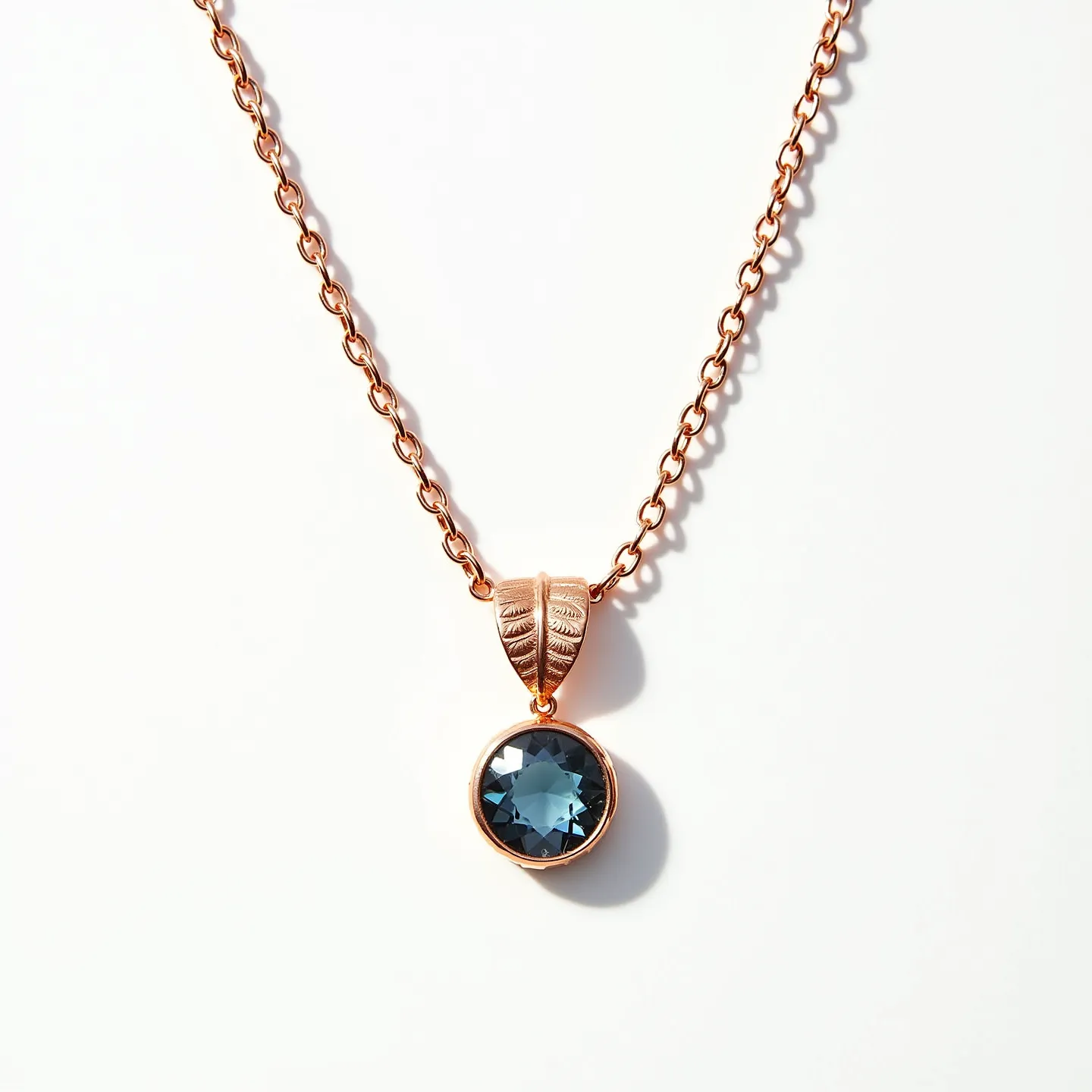 This birthstone necklace features a delicately crafted chain with a warm, rose gold finish, providing a smooth and elegant aesthetic. The pendant gracefully hangs with a detailed leaf-like design in the same rose gold material, adding a touch of nature-inspired artistry. Centrally set within this piece is a round, faceted blue gemstone, likely representing a birthstone such as sapphire or topaz, which captures and reflects light beautifully. The stone is securely held in a bezel setting, ensuring its prominence and safety. The necklace is completed with a sturdy clasp, offering both functionality and seamless integration with its sophisticated design.