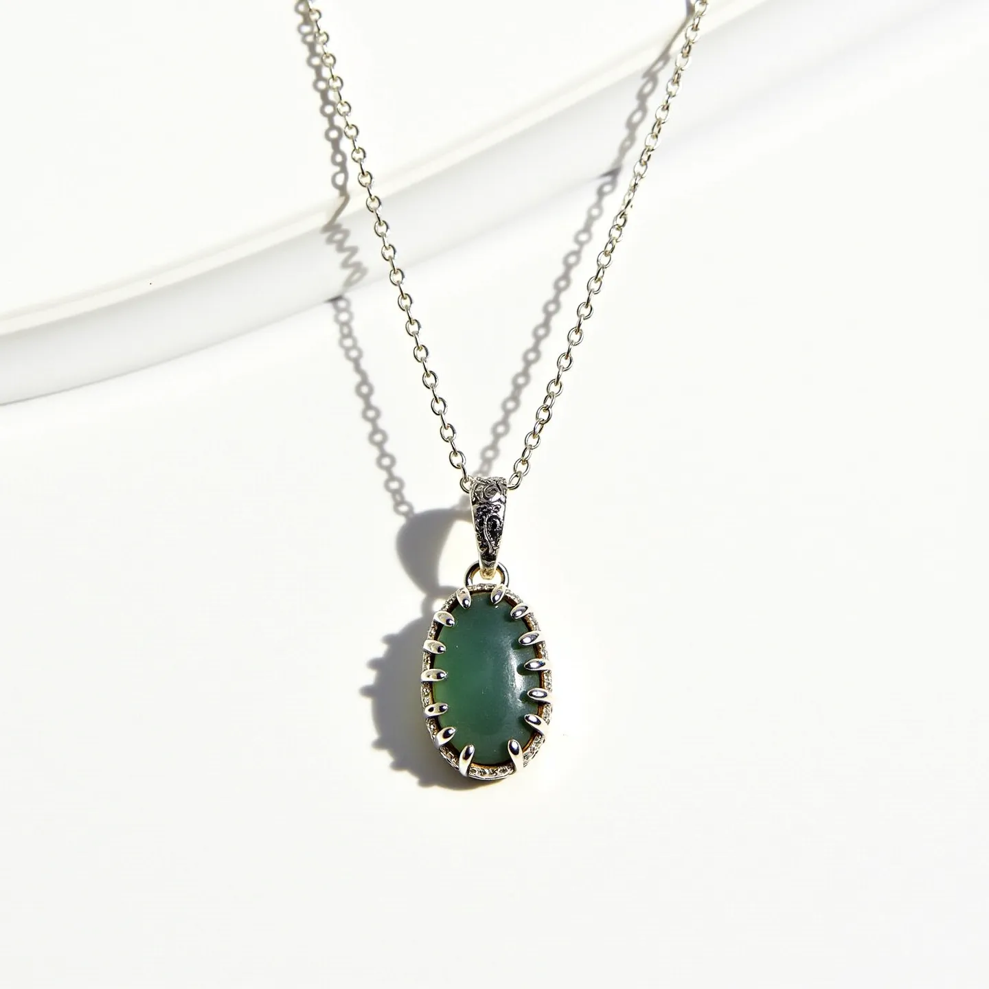 This birthstone necklace features a delicate chain crafted from a metal that appears to be either sterling silver or a polished base metal, providing a sleek and reflective finish. It is adorned with an oval-shaped green gemstone, which is set in a distinctive prong setting that enhances its visibility and guards it securely. The prongs are elegantly detailed with small embellishments, adding a touch of sophistication to the piece. The pendant is connected to the chain through an ornate bail, which matches the detailed design of the prongs, creating a harmonious overall appearance. The necklace is equipped with a simple clasp mechanism, ensuring ease of wear and security.