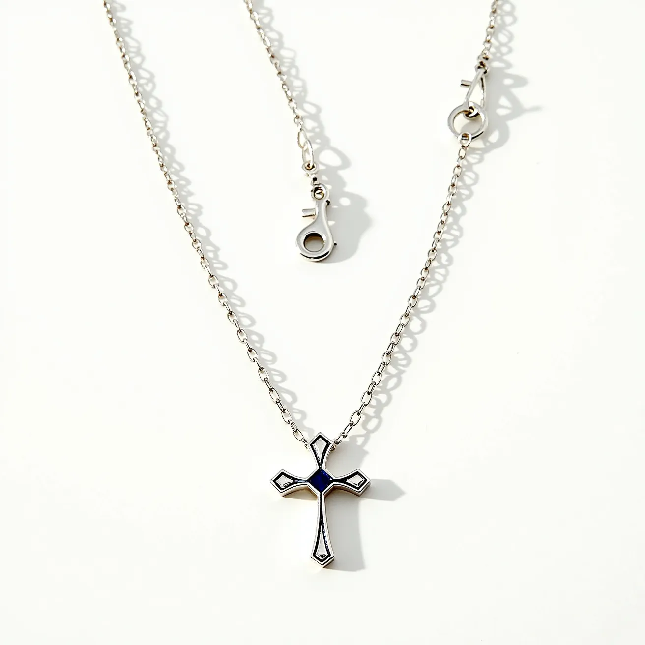 This boy's cross necklace features a simple yet elegant design crafted from a silver-toned metal that gives it a polished and refined appearance. The cross is accentuated with black enamel inlaid within its structure, offering a striking contrast. The necklace is attached to a delicate chain that complements the cross, allowing it to hang gracefully. A sturdy lobster clasp is used for securing the necklace, ensuring that it stays comfortably and securely in place when worn.