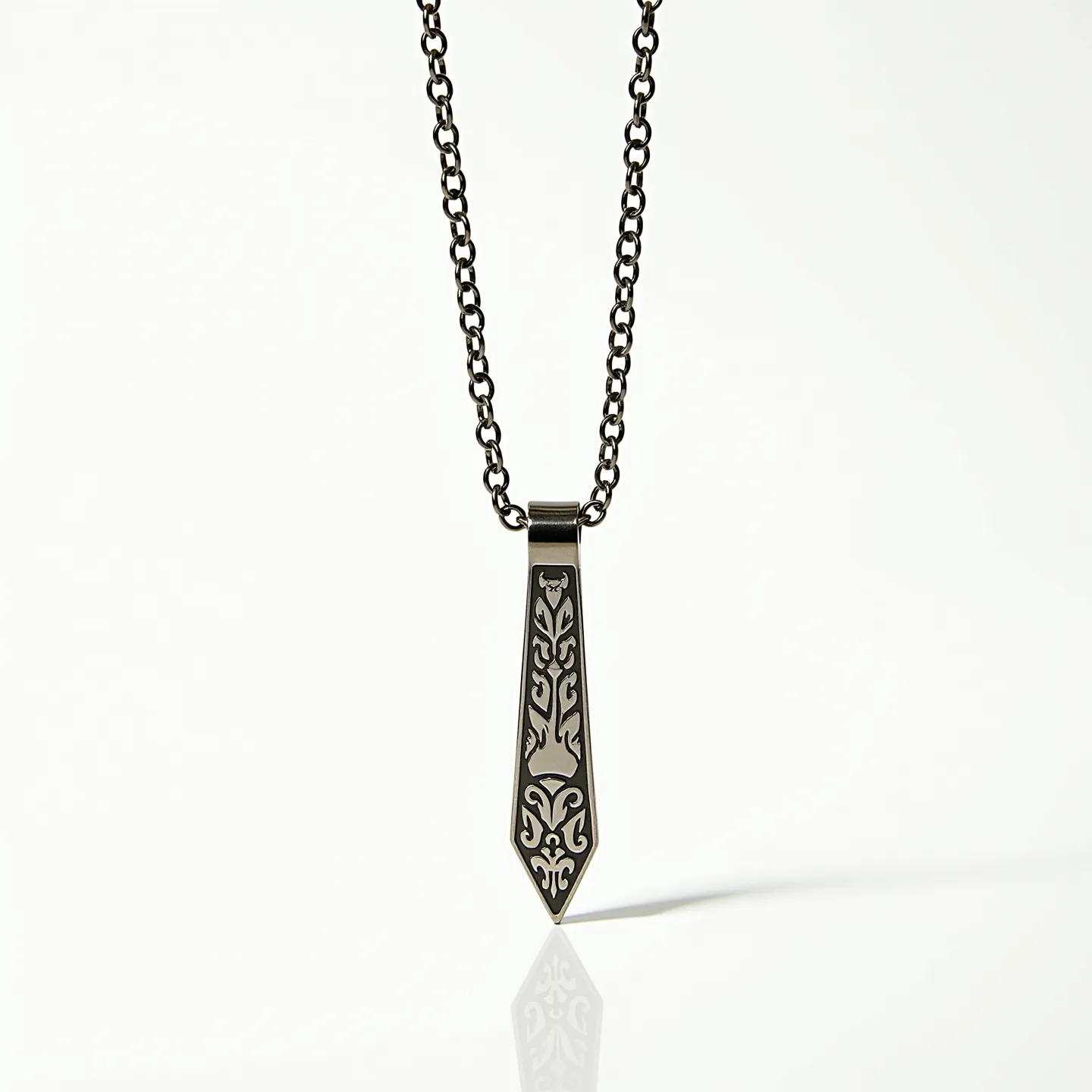 This boy's necklace features a chain crafted from metal links, likely stainless steel, providing durability and a polished finish. The pendant is an elongated metal piece, shaped like a stylized tie with intricate engraved patterns that may be symbolic or decorative. The geometric design adds visual interest without the inclusion of gemstones. It is secured with a standard clasp, ensuring it remains safely around the neck when worn.