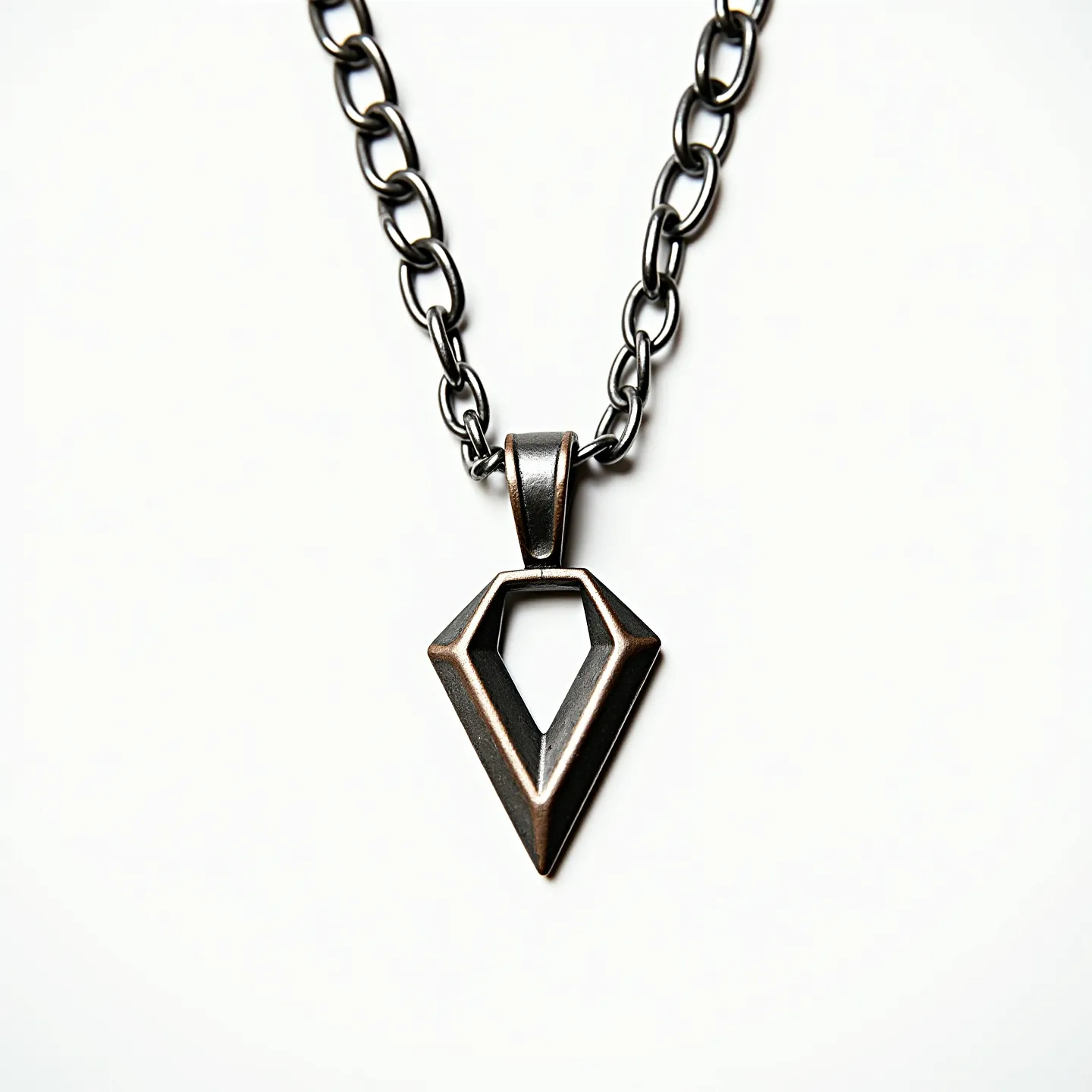 This boy's necklace features a sturdy metal chain with large, interlocking links that appear to have a silver or dark metallic finish. The focal point of the piece is a geometric pendant shaped like a stylized arrowhead or diamond with an open center, also made from a similar metallic material. The design highlights sharp lines and angles, giving it a modern and edgy aesthetic. The pendant is attached to the chain via a simple bail that complements the metallic theme. The clasp is not visible in the image, so its style cannot be described, and there are no gems or stones present in the design.