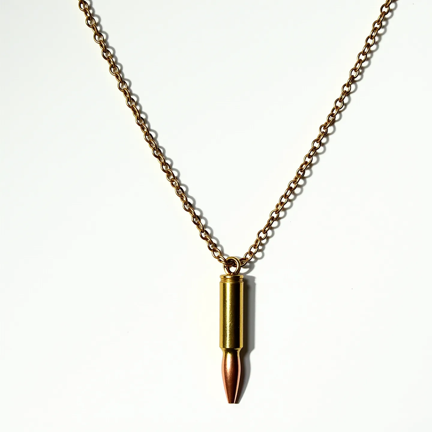 This bullet necklace features a realistic bullet pendant made of metal, primarily brass and copper tones, which suggest materials such as brass casing with a copper tip. The pendant is attached to a matching chain, likely composed of metal links that complement the bullet's metallic appearance. The bullet connects to the chain via a small loop or ring at the top of the casing, serving as the attachment point. The chain's design is uniform, projecting a strong, industrial aesthetic. The necklace does not incorporate any gemstones or additional embellishments, maintaining a minimalist look focused on the bullet motif.