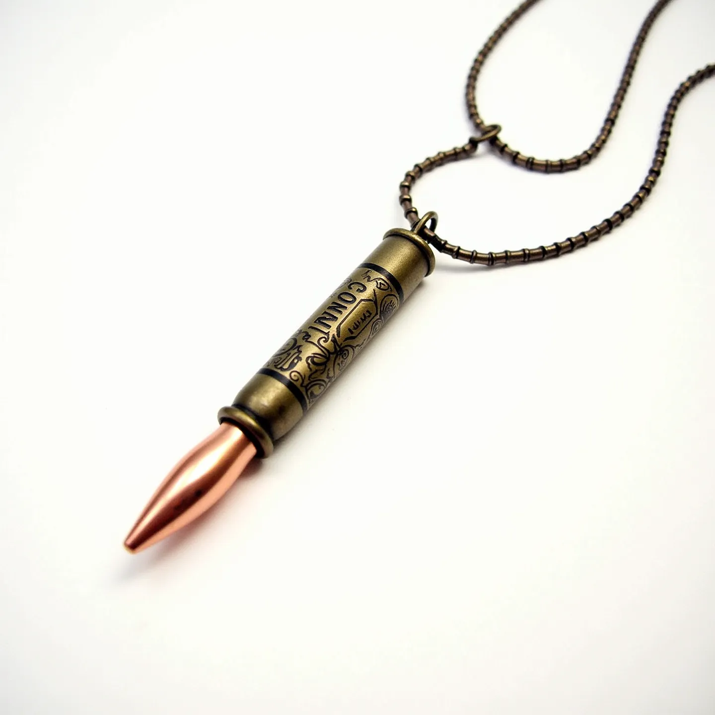 This bullet necklace features a distinct design combining metallic materials in its construction. The pendant resembles a bullet, crafted from a metal that has a bronze-like appearance with intricate engravings, adding decorative elements to its cylindrical surface. The tip of the bullet is a separate piece, appearing to be copper or a copper alloy, offering a contrasting color and texture. The chain is composed of small, interlinked metal beads, providing a robust and industrial aesthetic. The necklace is connected with a standard clasp that matches the chain's metallic tone, ensuring secure and comfortable wear.