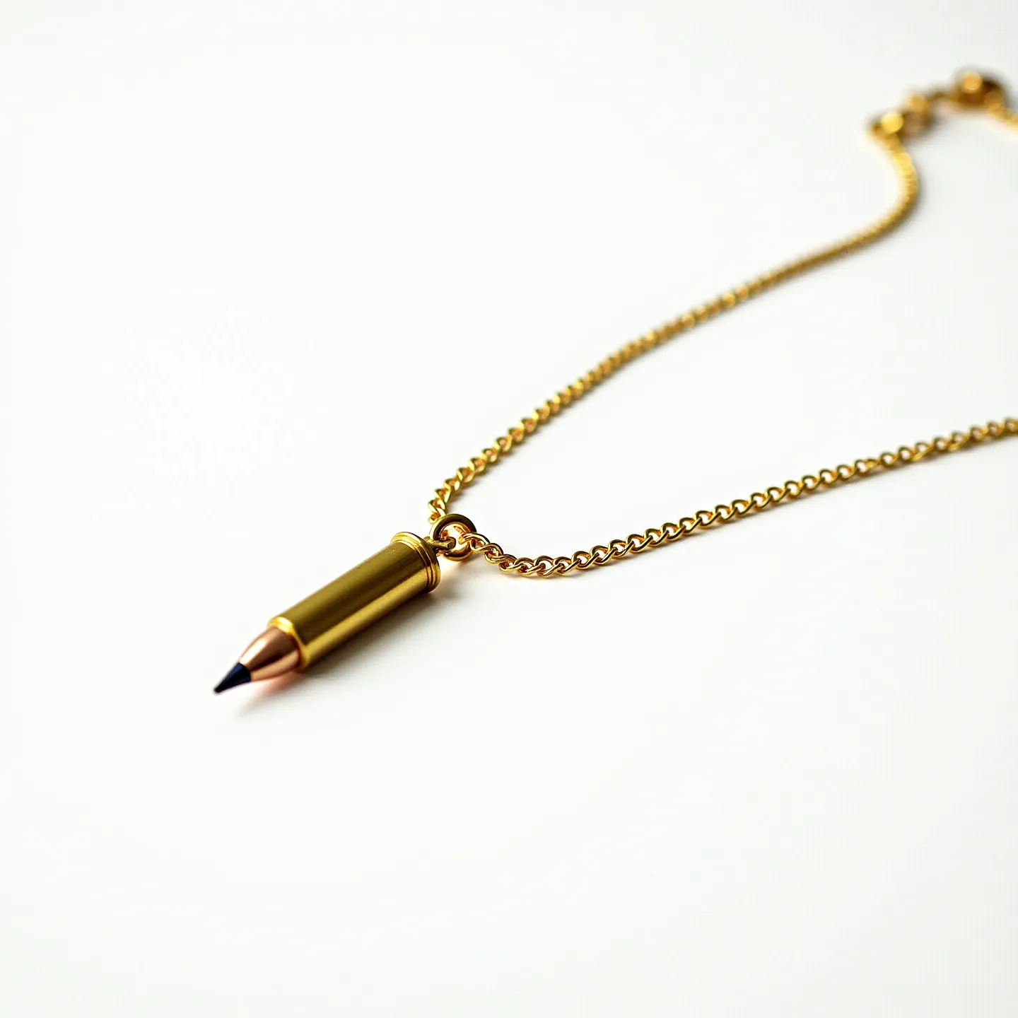 This bullet necklace features a pendant shaped like a bullet, crafted from a metallic material with a golden hue. The tip of the bullet has a distinctive dark point, suggesting a two-tone design that contrasts with the golden casing. The necklace is attached to a matching gold-toned chain, which is likely made of a durable metal, commonly used for jewelry. The chain appears to be a classic curb link style, providing a sturdy and elegant look. At the top of the bullet casing, there is a circular attachment connecting it to the chain, allowing the pendant to hang freely. The necklace is secured with a standard clasp, ensuring it is easy to wear and remove.