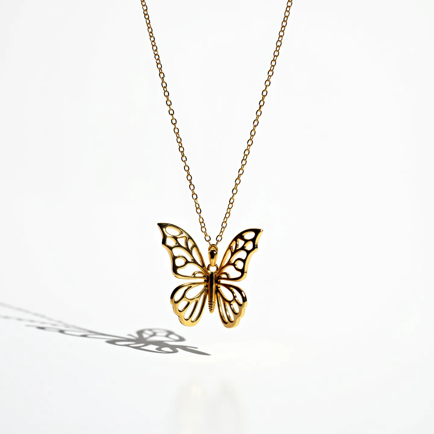 This butterfly necklace features a delicate, gold-toned metal pendant shaped like a butterfly with an intricate openwork design that highlights the elegance of its wings. The chain is fine and complements the pendant’s airy, graceful motif. The necklace likely secures with a typical lobster clasp commonly used for jewelry, ensuring it stays in place when worn. The pendant's craftsmanship suggests a careful, detailed approach to metalwork, creating a charming and sophisticated accessory.