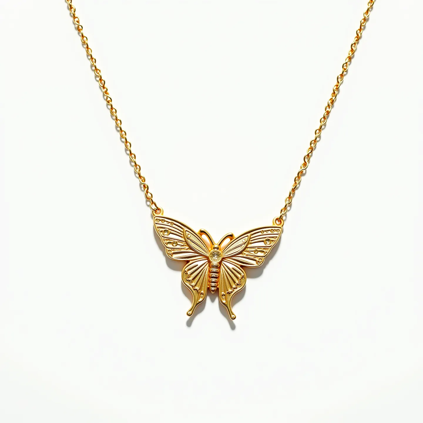 This butterfly necklace features a detailed butterfly pendant crafted from a golden material, likely gold or gold-tone metal. The pendant includes intricate patterns and designs on the wings, giving it a textured appearance. At the center of the butterfly is a small, round clear gemstone, possibly a diamond or cubic zirconia, set in a simple prong or bezel setting. The necklace is connected to a fine, gold-colored chain, which likely includes a standard lobster clasp for secure fastening. The design combines elegance with a whimsical touch, making it a versatile accessory.