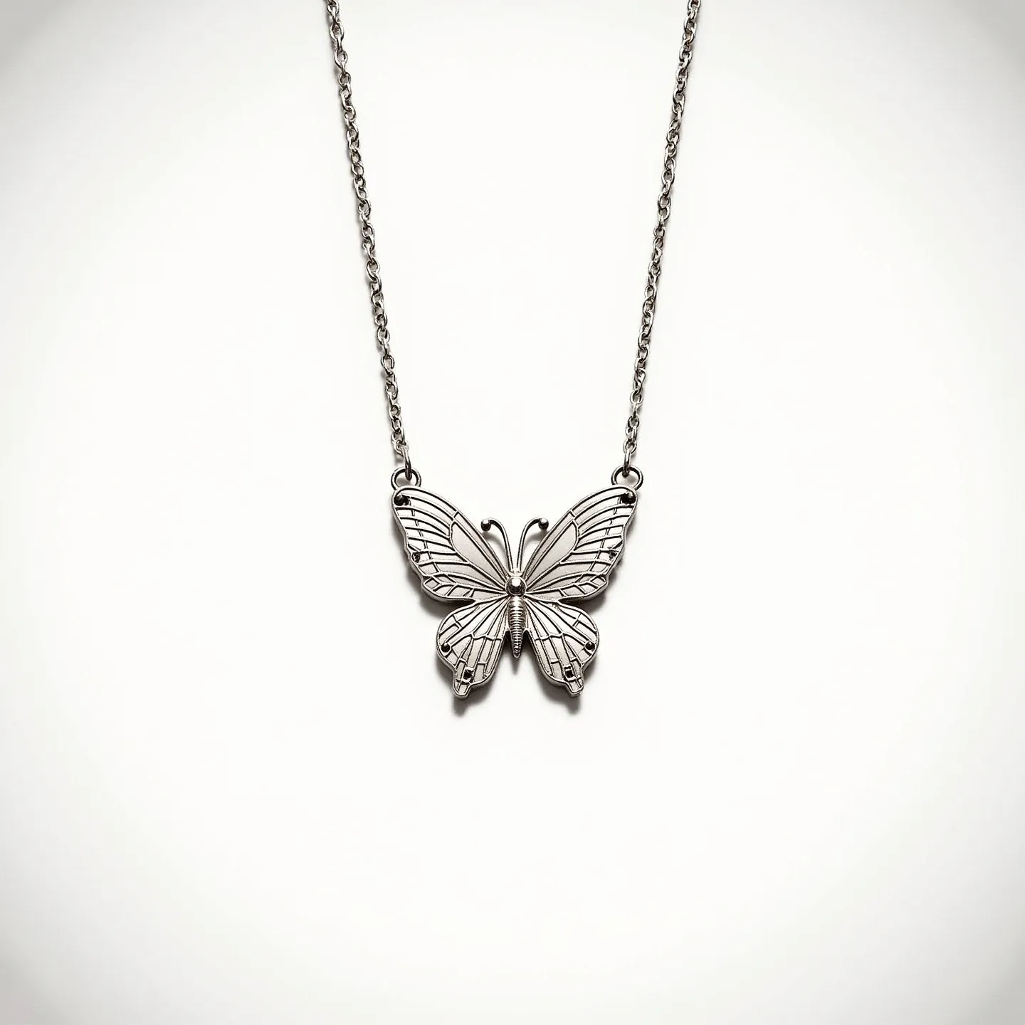 This butterfly necklace features a delicately crafted metal pendant in the shape of a butterfly, showcasing intricate linework that mimics the natural texture of butterfly wings. The pendant is suspended from a matching metal chain, highlighting the elegant simplicity of the design. The necklace does not appear to incorporate any gemstones or additional embellishments, focusing instead on the detailed craftsmanship of the butterfly motif. The chain is linked to the pendant directly, ensuring a cohesive and seamless aesthetic, and is likely secured by a standard clasp mechanism for ease of wear.