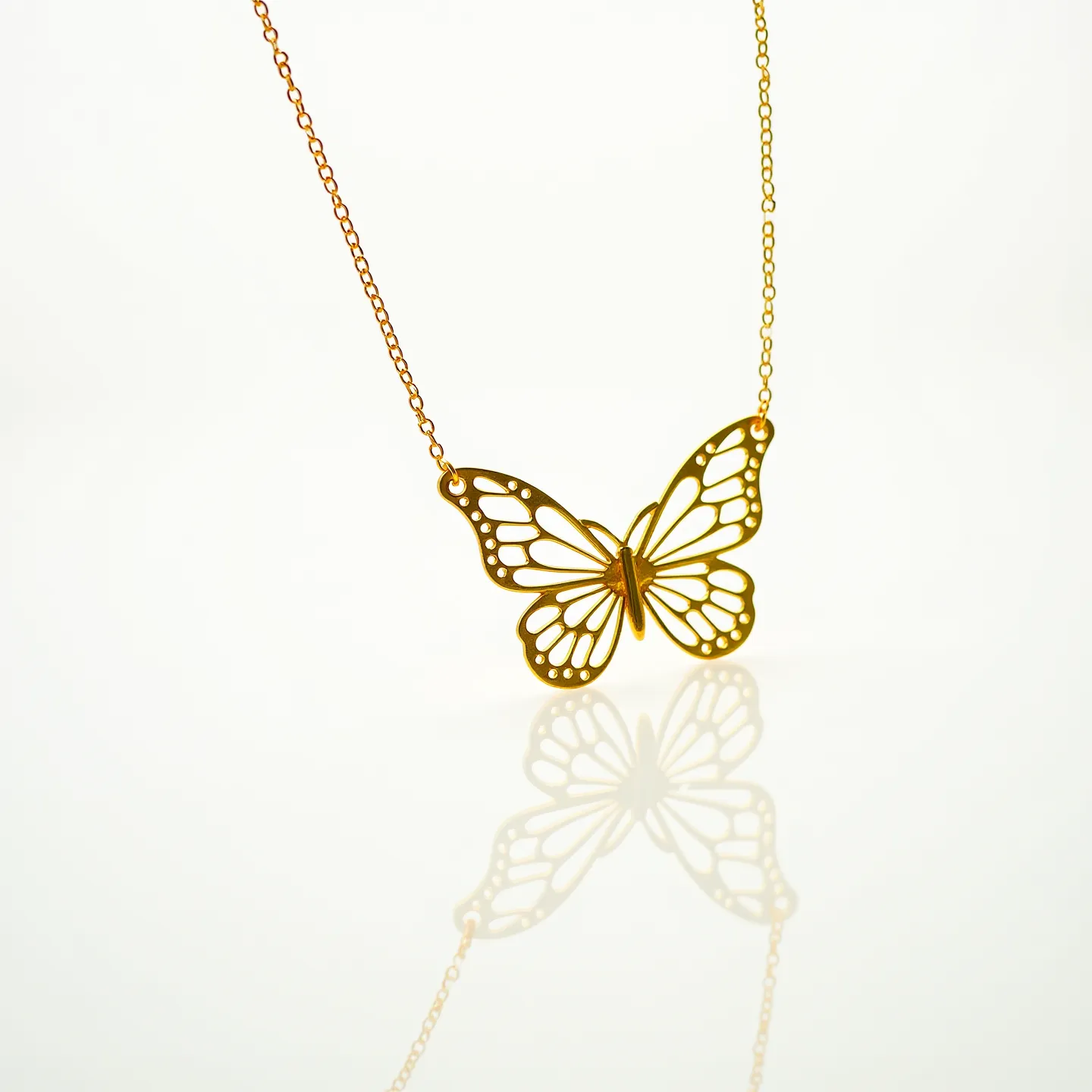 This butterfly necklace features a delicately crafted butterfly pendant with intricate openwork detailing. The butterfly is made from a gold-toned metal, lending it a subtle elegance and brilliance. The pendant is attached to a fine, matching chain, which is likely made of a similar gold-toned metal, providing a seamless look. The chain appears to have a basic loop clasp, ensuring a secure and comfortable fit. The overall design of the necklace is elegant and understated, highlighting the beauty of the butterfly motif.