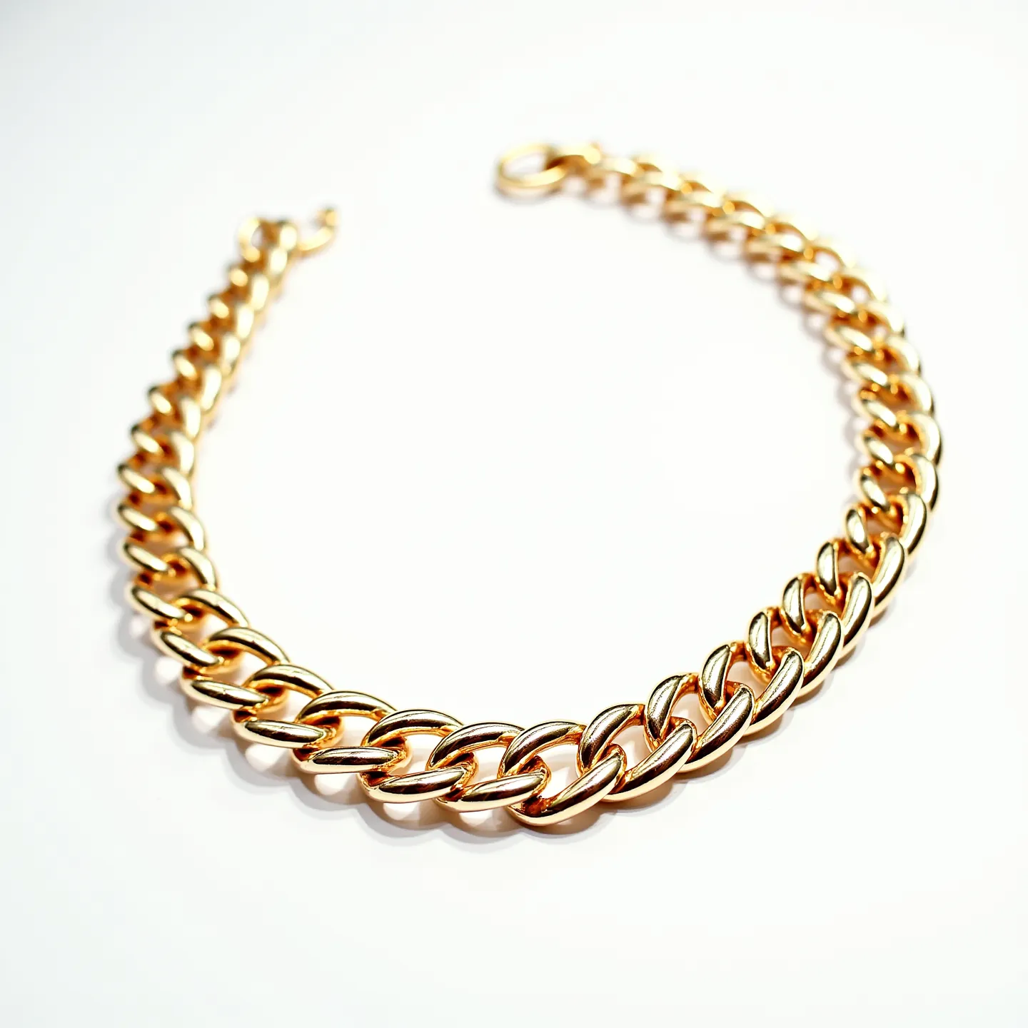 This cable chain features interlocking links crafted from a shiny gold material, giving it a polished and elegant appearance. The links are uniformly sized and smoothly finished, adding to the chain's overall refined design. It is equipped with a sturdy lobster clasp, ensuring secure fastening. The chain does not incorporate any gemstones, focusing instead on the classic appeal of its gold-toned links.