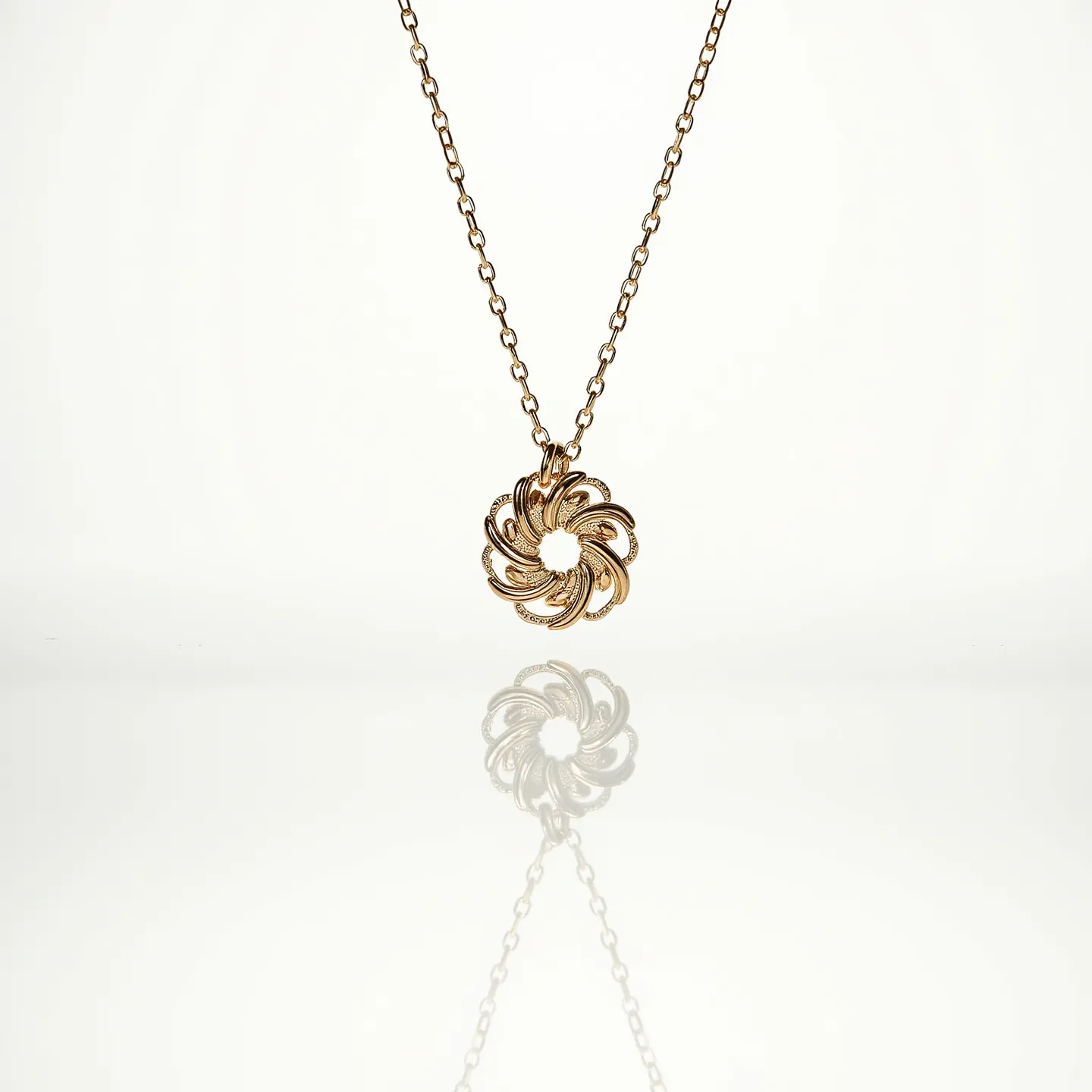 This cable chain is made of a gold-toned metal, featuring a round pendant with a spiral design. The pendant appears to be intricately crafted, showcasing swirling shapes that give it a floral or geometric pattern. There are no visible gems or stones set within the pendant, which maintains a uniform metallic appearance. The chain links are evenly spaced with a smooth finish, contributing to the necklace's elegant and simple design. A clasp is not visible, suggesting it may be situated towards the back or designed to blend seamlessly with the chain's style.