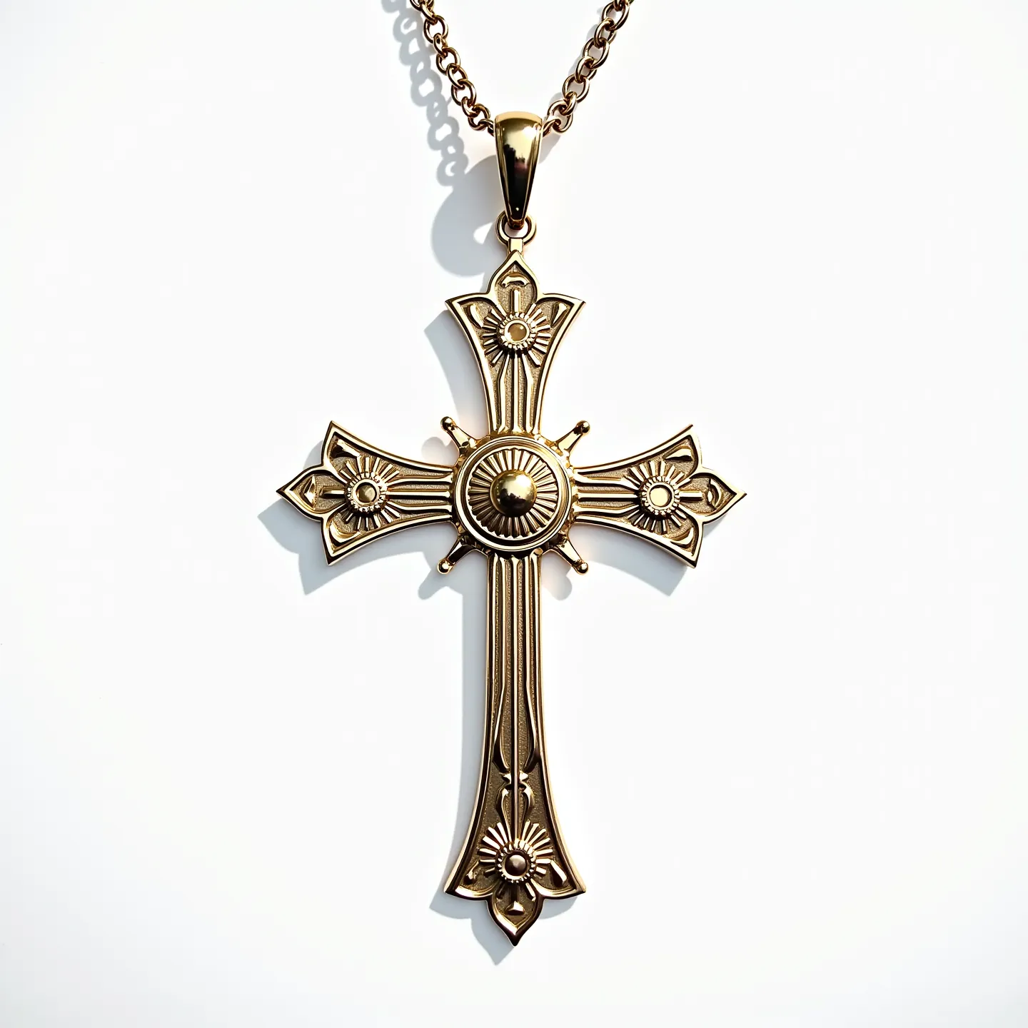 This catholic cross necklace showcases an ornate design, featuring a gold-toned metal as its primary material. The cross is adorned with intricate patterns resembling floral motifs at each end, radiating from a central circular element that adds depth and elegance. It appears to be crafted with meticulous attention to detail, enhancing its overall aesthetic. The necklace is suspended from a matching gold-toned chain, which is seen linked through a sleek, polished bail that complements the ornate design of the cross itself. The connector or clasp remains discreet, maintaining the focus on the exquisite craftsmanship of the cross pendant.