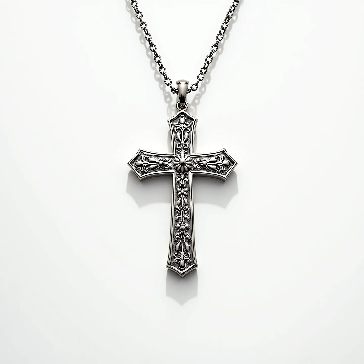 This Catholic cross necklace features a beautifully crafted design made from metal, likely silver, showcasing intricate detailing reminiscent of filigree work. The cross itself is adorned with ornate patterns along its surface, giving it a vintage or gothic appeal. While the necklace does not appear to incorporate any gemstones, the precision and artistry of the metalwork give it a distinctive and elegant look. The cross hangs from a solid chain with a simple but secure bail attachment that allows for easy wear. The chain itself consists of interlocked metal links, adding to its durability and classic aesthetic.