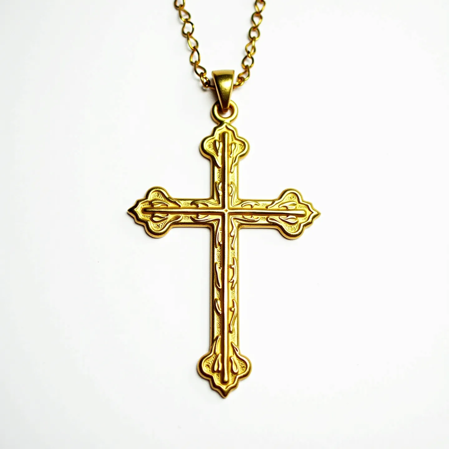 This catholic cross necklace features an ornate gold-tone cross with intricate detailing on its surface, showcasing a classic and elegant design. The cross is attached to a chain with a matching gold hue, suggesting it may be composed of a durable metal with a golden finish. The chain appears to be linked, offering flexibility and comfort for wear. The cross is affixed to the chain through a secure loop at the top, ensuring stability. There are no visible gems or stones, allowing the craftsmanship and design of the cross to stand out. The overall appearance of the necklace is sophisticated and timeless, making it a meaningful accessory.