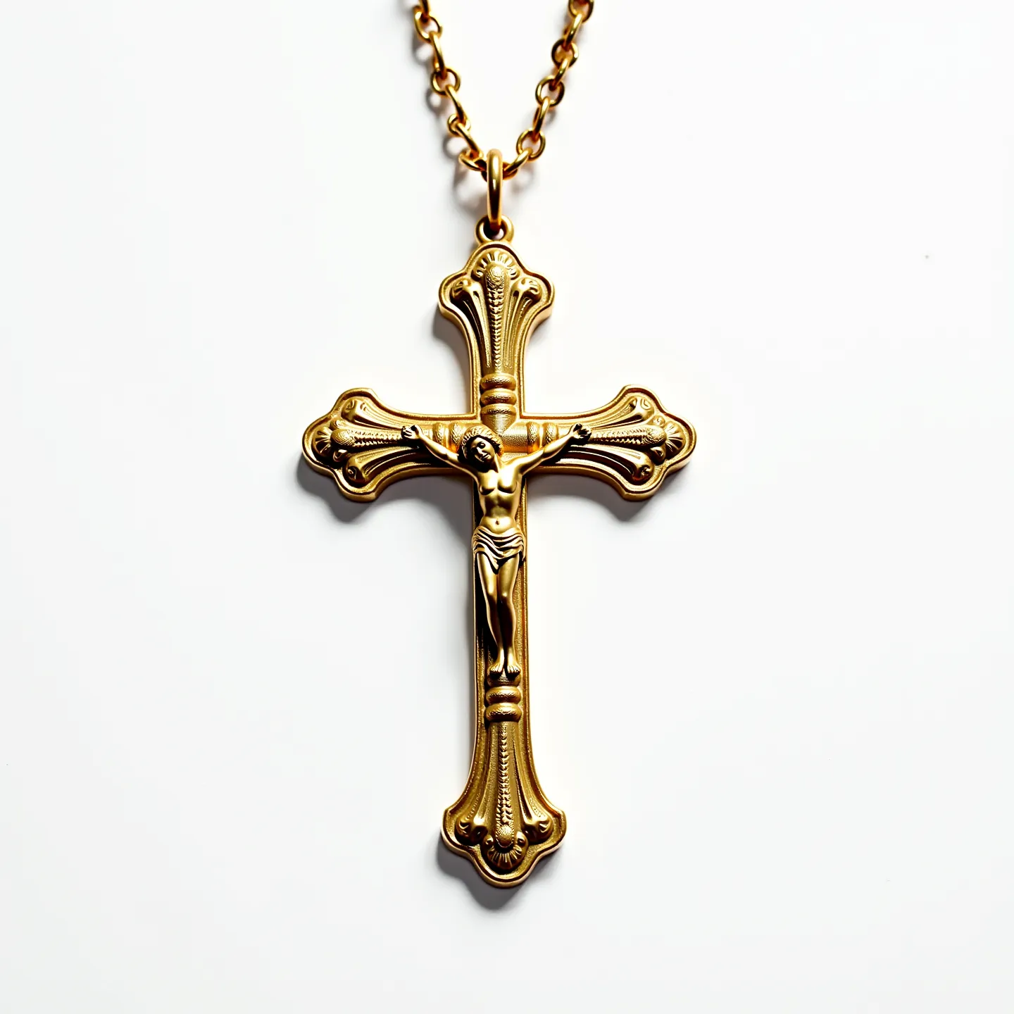 This catholic necklace features a beautifully crafted gold-toned cross, adorned with intricate, ornate detailing that highlights the traditional design often associated with religious jewelry. In the center of the cross is a depiction of the crucifixion, meticulously designed to evoke reverence and devotion. The pendant hangs from a chain made of linked loops, emphasizing durability while complementing the cross's dignified appearance. The connection between the cross and the chain is seamless, allowing for fluid movement and comfortable wear. The necklace's clasp is designed to ensure secure fastening while maintaining ease of use.