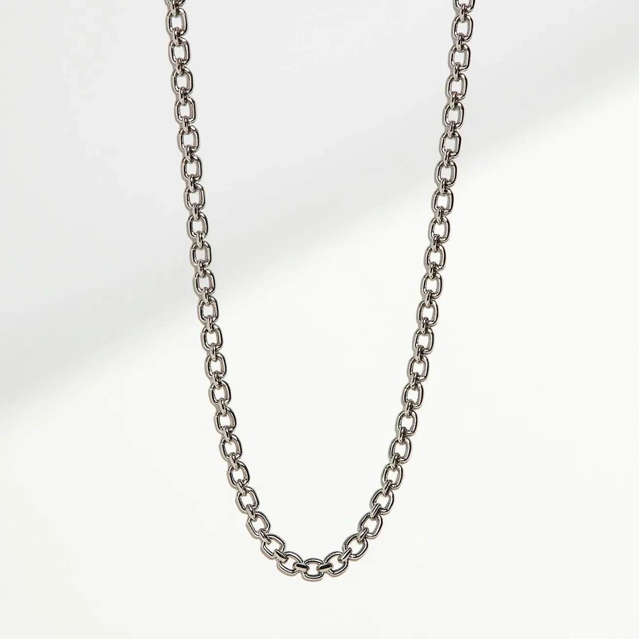 This chain link necklace is crafted from a polished metal, likely stainless steel, providing a sleek and durable appearance. The links are uniformly oval-shaped and interconnected, creating a classic and timeless design. The necklace features a lobster clasp, offering secure and easy fastening. The simplicity of its structure makes it versatile and suitable for everyday wear or as a base for pendants and charms.