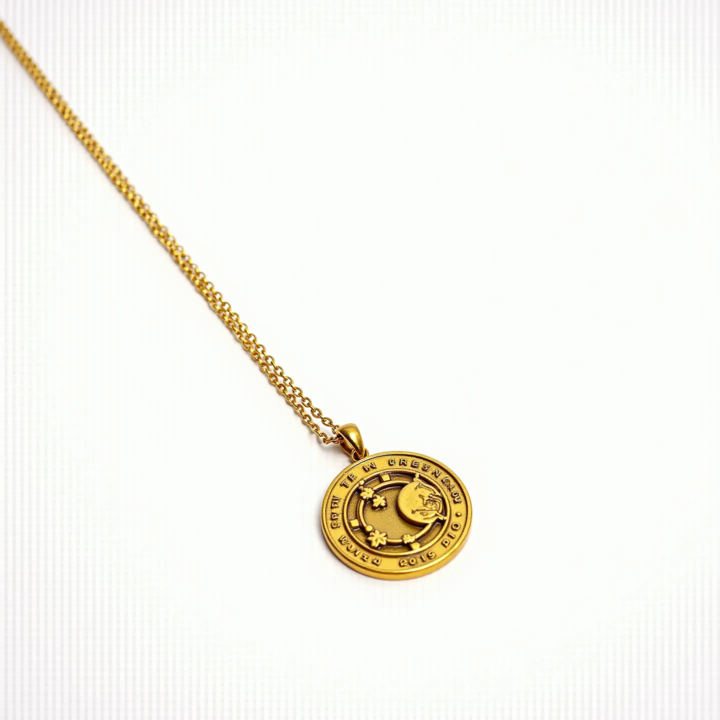 This charm necklace features a circular gold-toned pendant with intricate embossed designs, showcasing celestial motifs like stars and crescent moons. The pendant is suspended from a delicate, matching gold-toned chain, which neatly complements its shiny texture. The chain appears to have a simple yet elegant link design, adding a classic touch to the overall aesthetic. The attachment includes a smooth bail that seamlessly connects the pendant to the chain, ensuring a coherent look. This necklace combines both elegance and charm, making it a versatile accessory for various occasions.