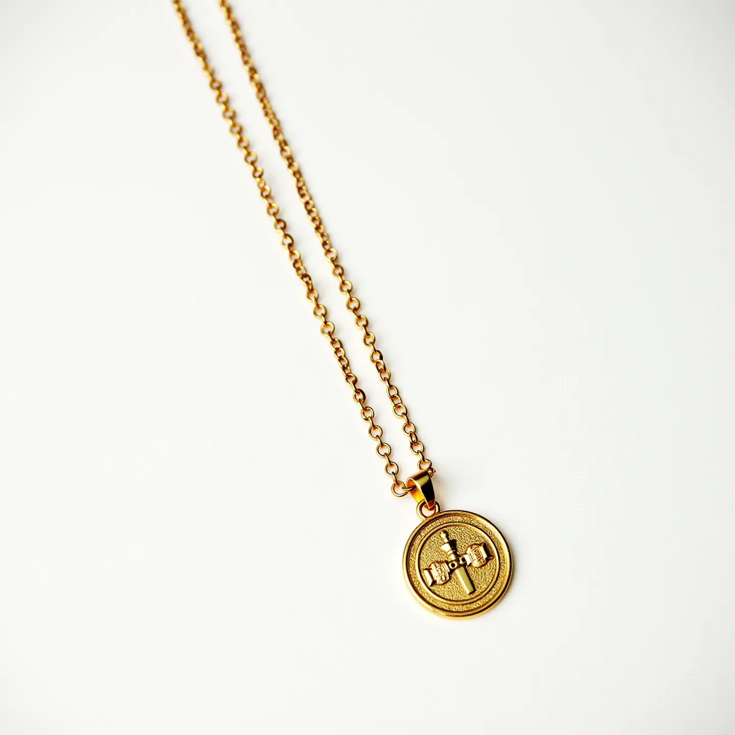 This charm necklace gold features a delicate chain composed of interconnected links, showcasing a warm, golden hue. At its center hangs a circular charm with embossed details, adding a touch of intricate design to the piece. The charm is attached to the chain by a simple loop, ensuring it remains secure and elegant in its position. There are no visible gemstones or embellishments on the charm, maintaining a minimalist aesthetic. The necklace is completed with a standard clasp, providing ease of attachment and removal.