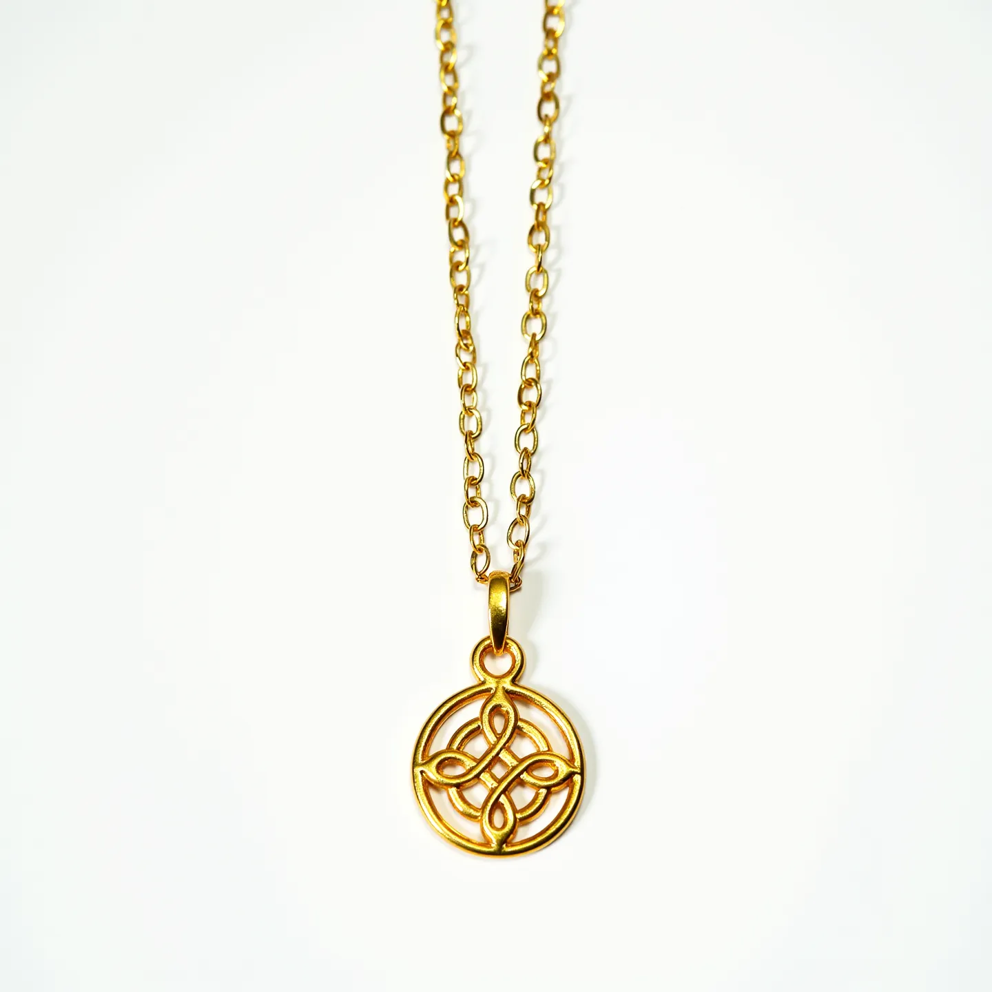 This charm necklace gold features a delicate, round pendant with an intricate Celtic knot design, showcasing exceptional craftsmanship. The pendant is made of polished gold, exuding a classic and elegant appeal. It hangs gracefully from a fine chain composed of small, interlocking links that create a uniform and seamless flow. The necklace is secured with a simple and functional clasp that ensures ease of wear while maintaining the overall aesthetic. The absence of gemstones or additional embellishments emphasizes the purity and allure of the gold itself.