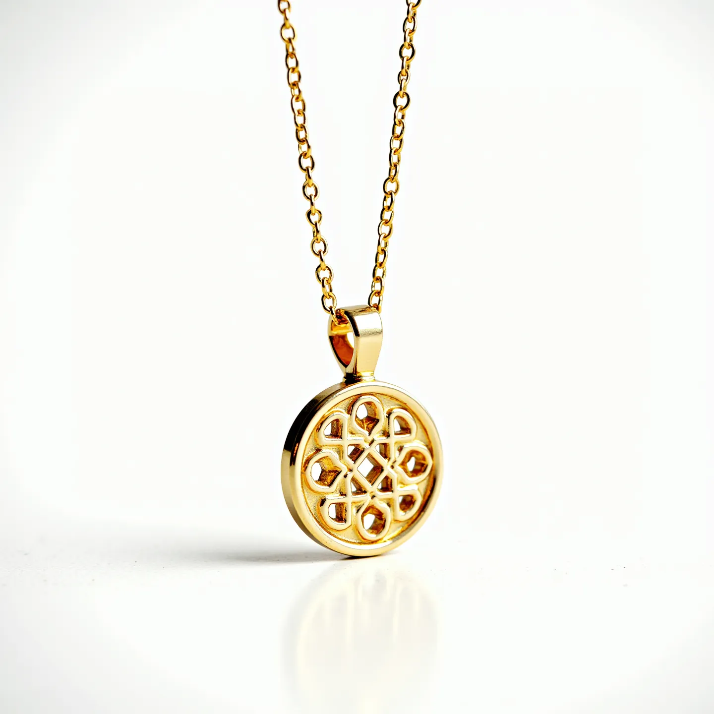 This charm necklace gold features a round pendant crafted from a polished gold material, exhibiting a delicate openwork design. The intricate pattern within the pendant showcases an elegant geometric motif. Hanging from a fine gold cable chain, the pendant is secured by a smooth bail that seamlessly complements its design. The necklace is elegantly finished with a secure lobster clasp, ensuring ease of wear and a sophisticated look.